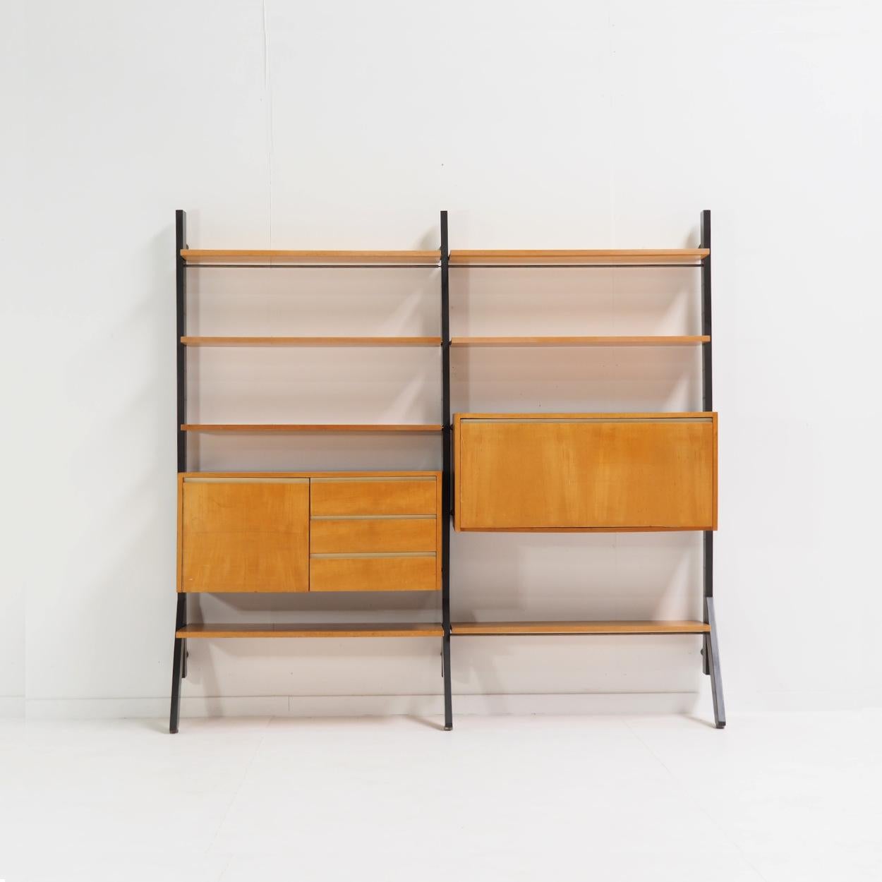 Hängeschrank 'Module', entworfen 1956 von Kho Liang Ie für das niederländische Möbelunternehmen Fristho.

Die Schrankwand ist aus Buche und dunkelgrau lackiertem Holz gefertigt und besteht aus Regalen, einem Ablagefach und einem Sekretärelement. In