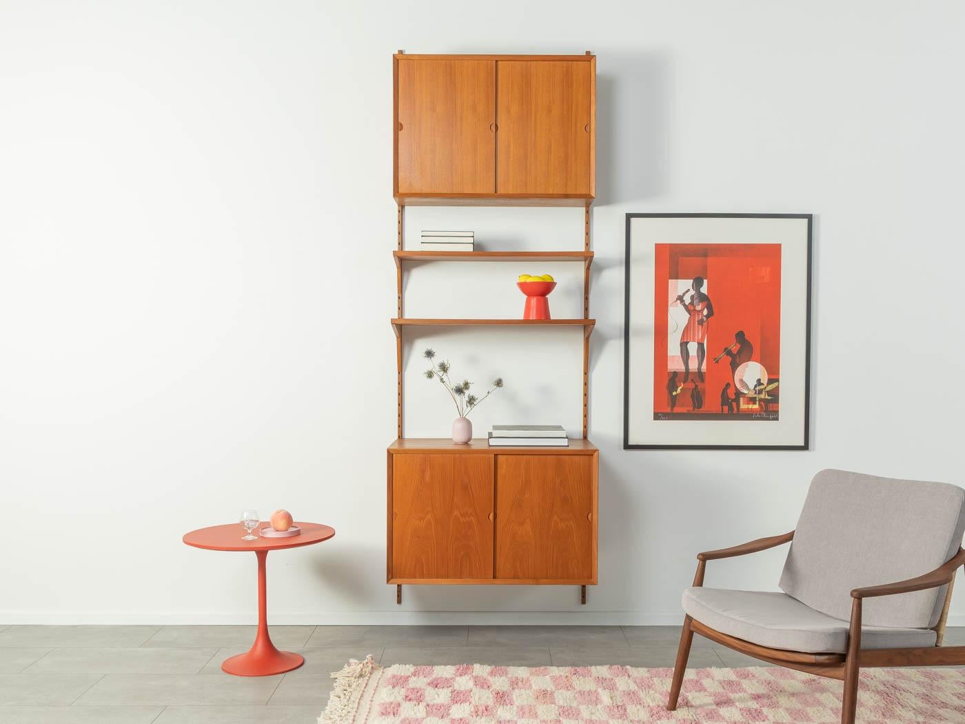 Classic shelving system from the 1960s. The high-quality containers and shelves are veneered in teak. The system consists of two shelves, two containers with sliding doors, four shelves and two wooden ladders.
Quality features:

 Accomplished