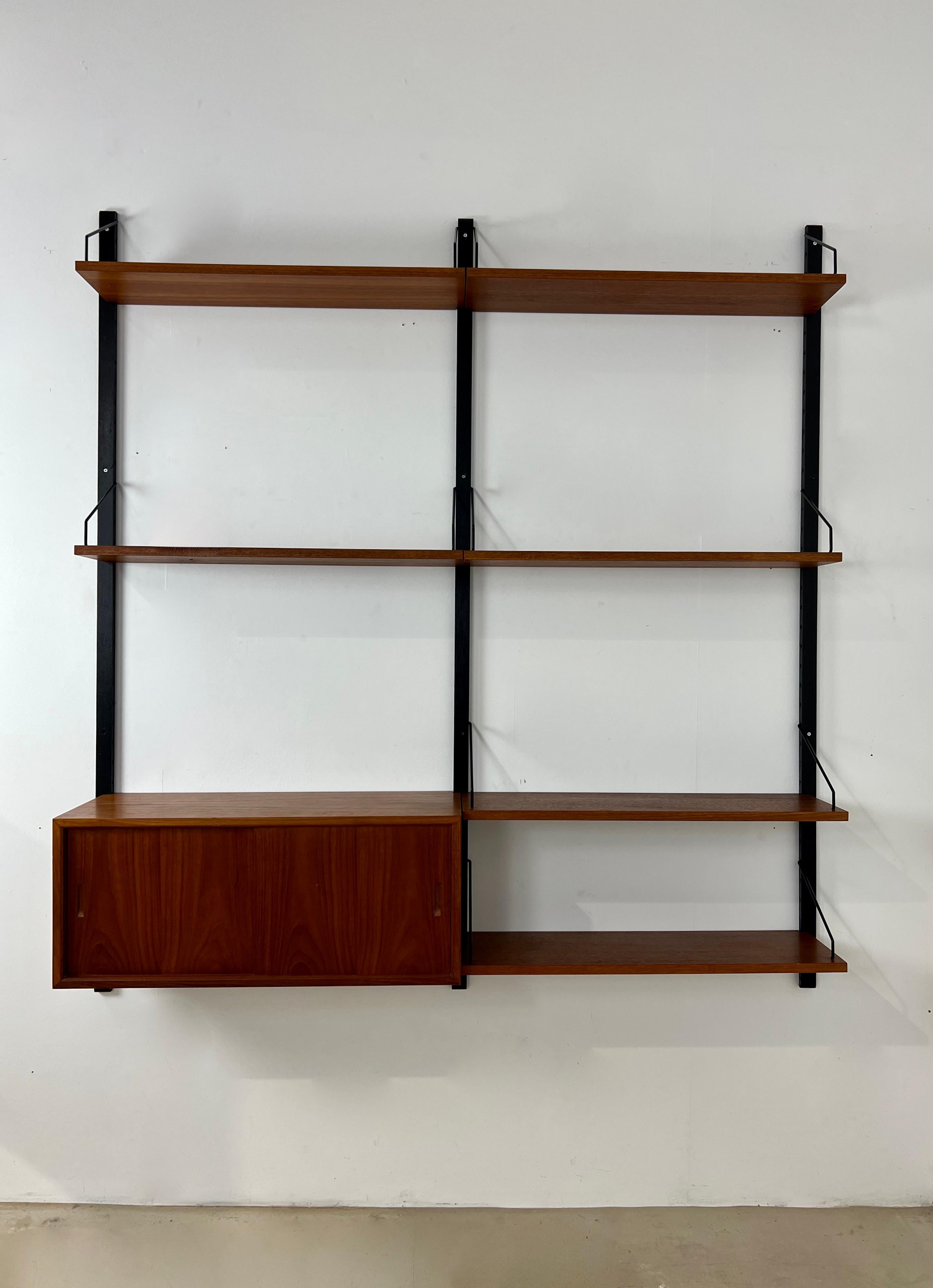 Wall unit composed of 3 posts, 6 boards and a storage box. Stamped Poul Cadovuis. Wear due to time and age of the wall unit (see photo)