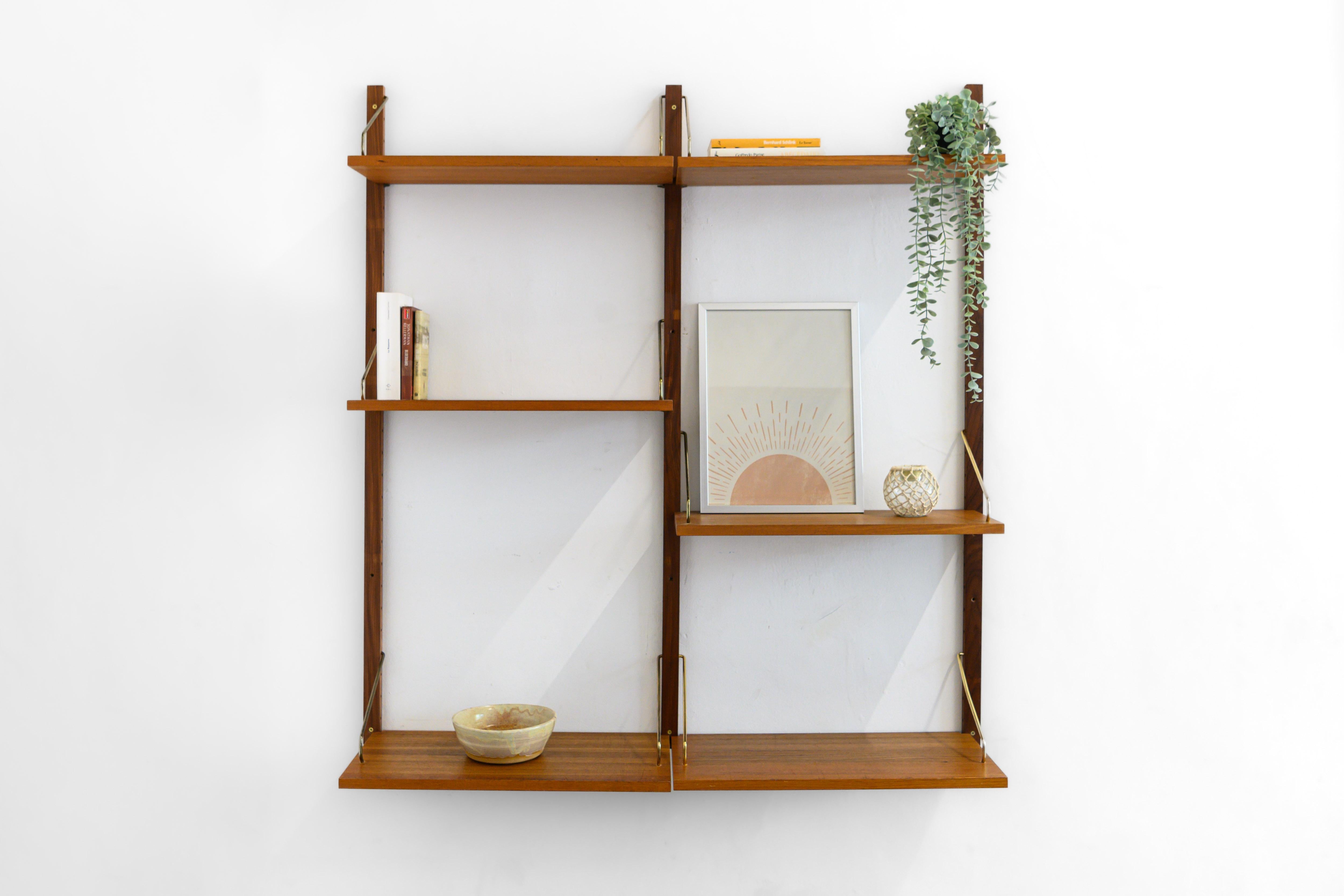Danish modular wall unit by Poul Cadovius for Royal System. This teak setup has six bookshelves and this setup has the brass support hooks. Always adaptable and further expandable.