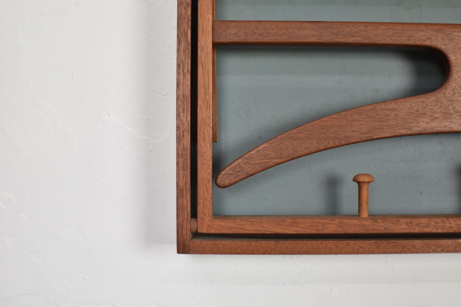 Authentic wall-mounted valet by Adam Hoff & Poul Østergaard for Virum Møbelsnedkeri, Denmark 1963. This lovely coat rack is made out of teak and got two naturel leather straps, the back is finished in dark green formica. Excellent condition with