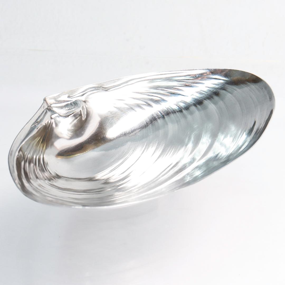 A fine vintage American figural sterling silver bowl.

By Wallace.

Model no. 393.

In the form of a half clam shell supported by a crescent shaped foot.

Simply a wonderful piece of Beach themed silver!

Date:
20th Century

Overall Condition:
It is
