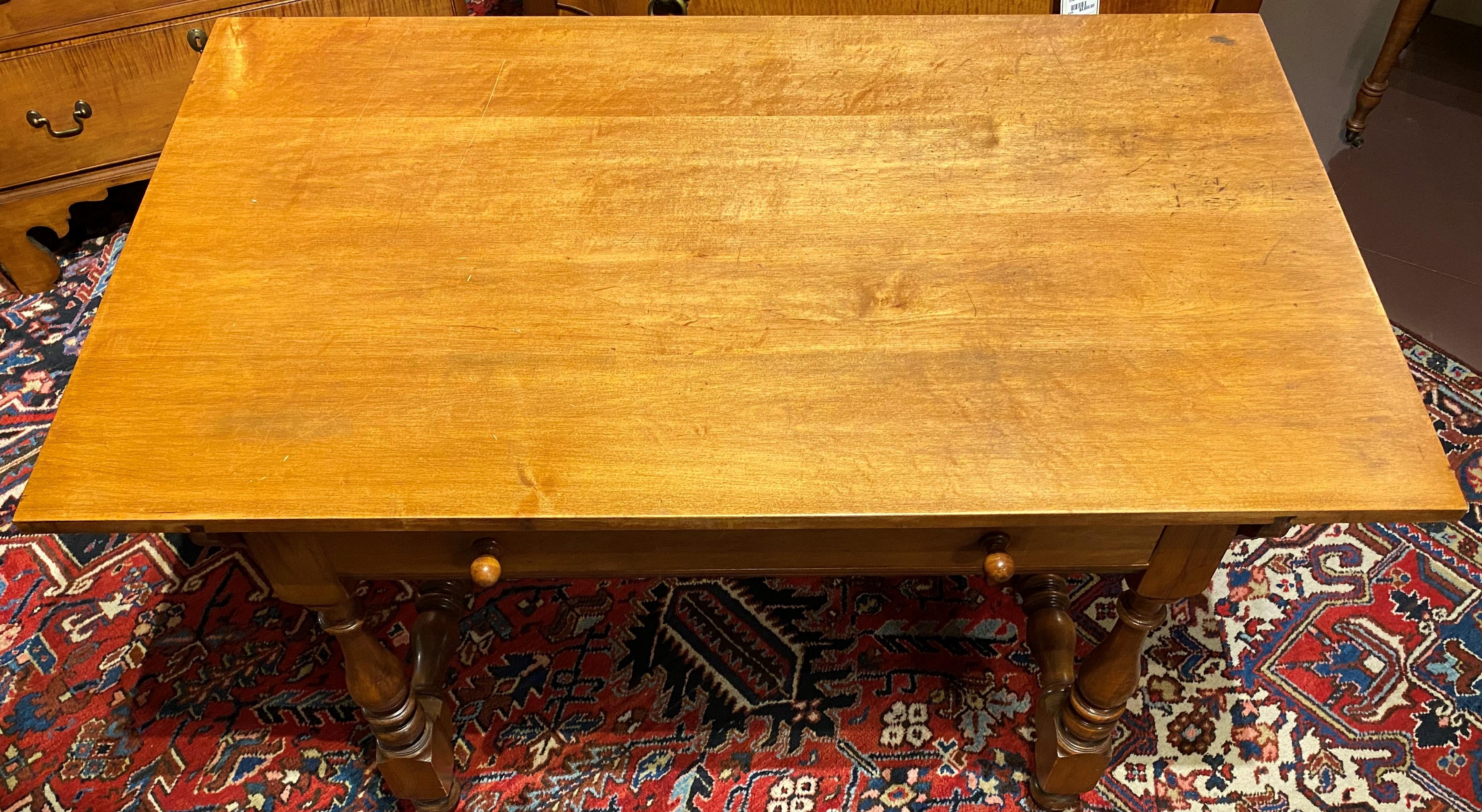 A fine rectangular maple one drawer tavern table with boldly turned legs and H form turned stretchers, the overhanging top secured with four handled pegs, and “Wallace Nutting” stamped inside the drawer. This table dates to the mid 20th century and