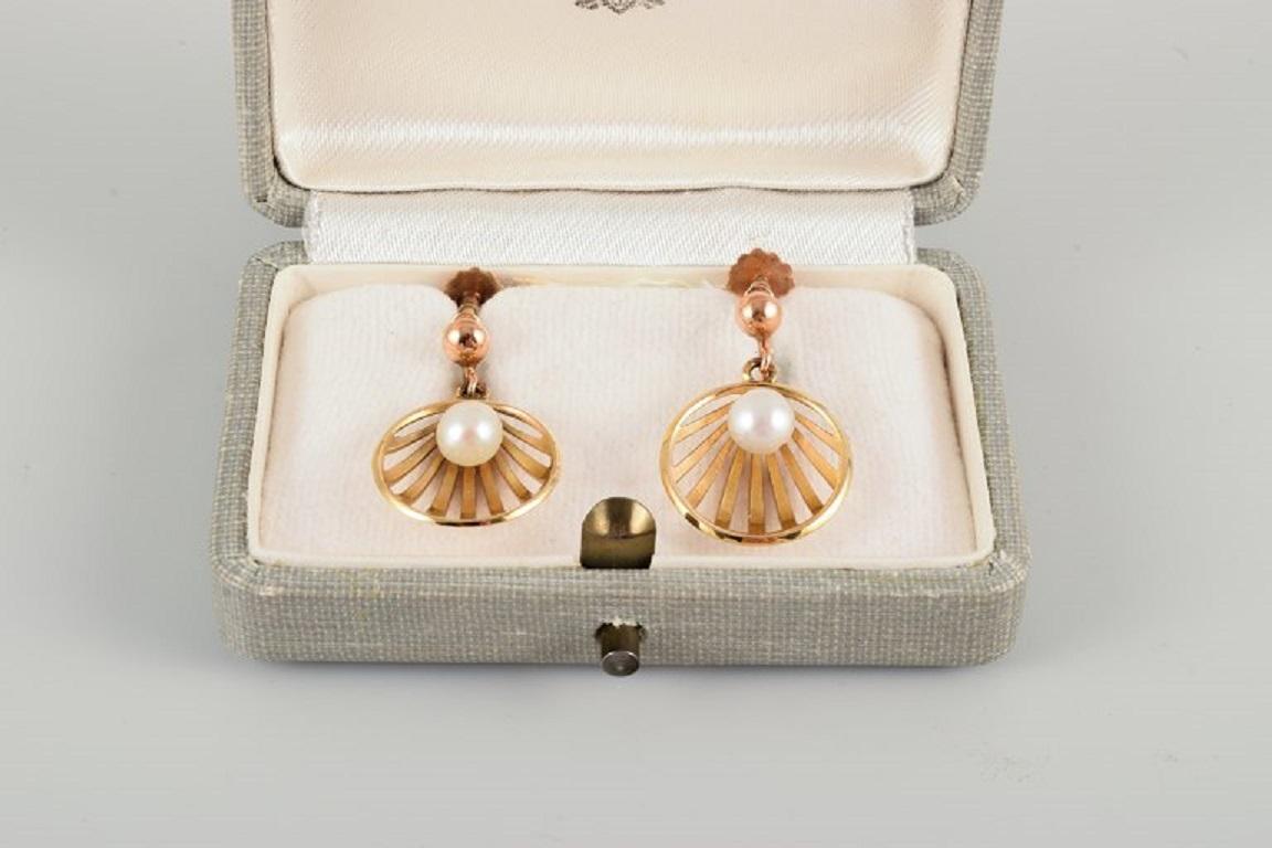 Wallins, Sweden.
A pair of earrings in 14 carat gold adorned with cultured pearls.
Dated 1903.
Total length 30mm D 15mm
In excellent condition.
Original box from A. Tillander included.
Marked.