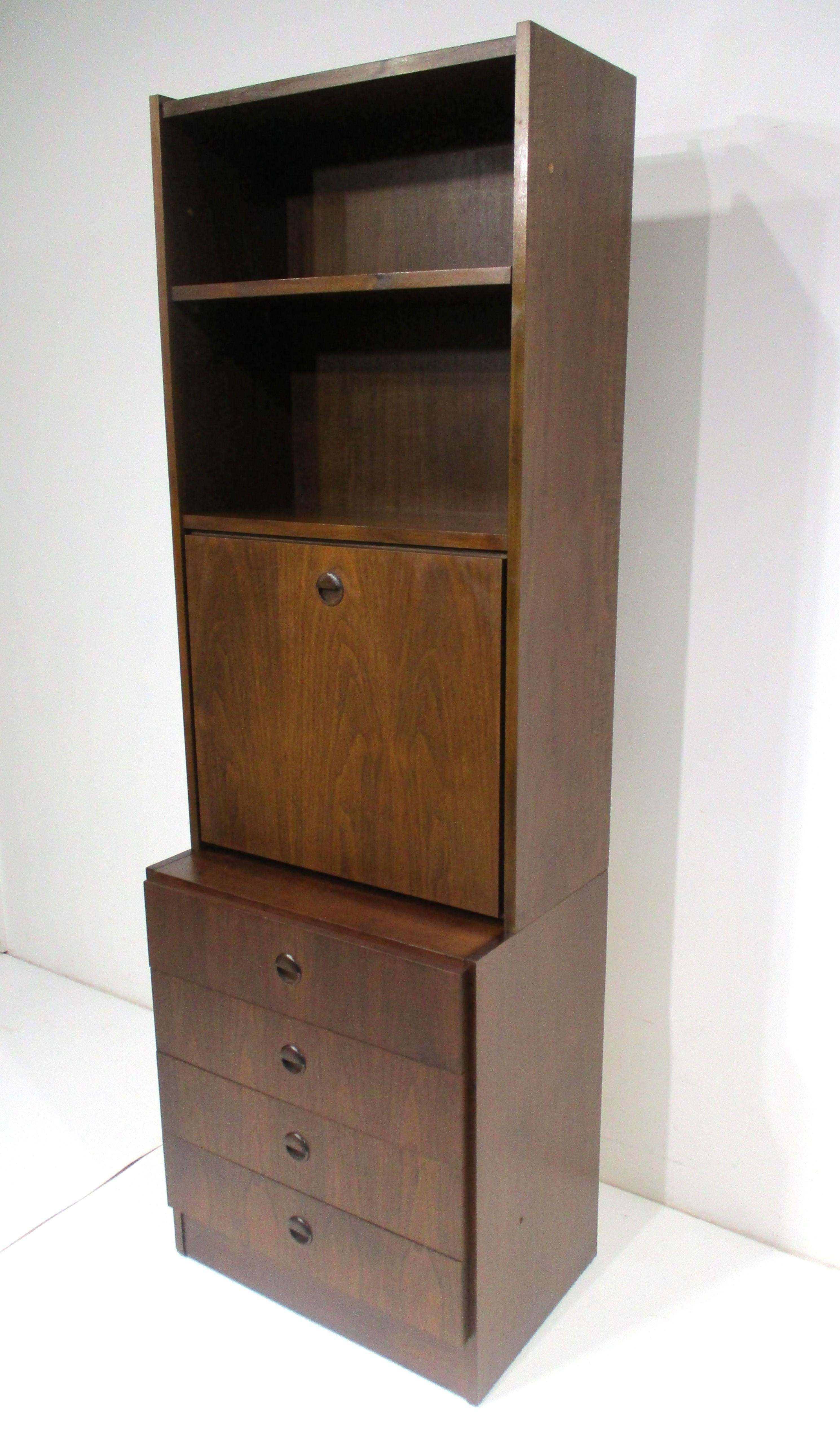 A two piece dark walnut pull down desk with upper bookcase having two adjustable shelves and four drawers to the base for storage . The front when down has a birch wood contrasting work surface and a white laminate back area with small cubbies and