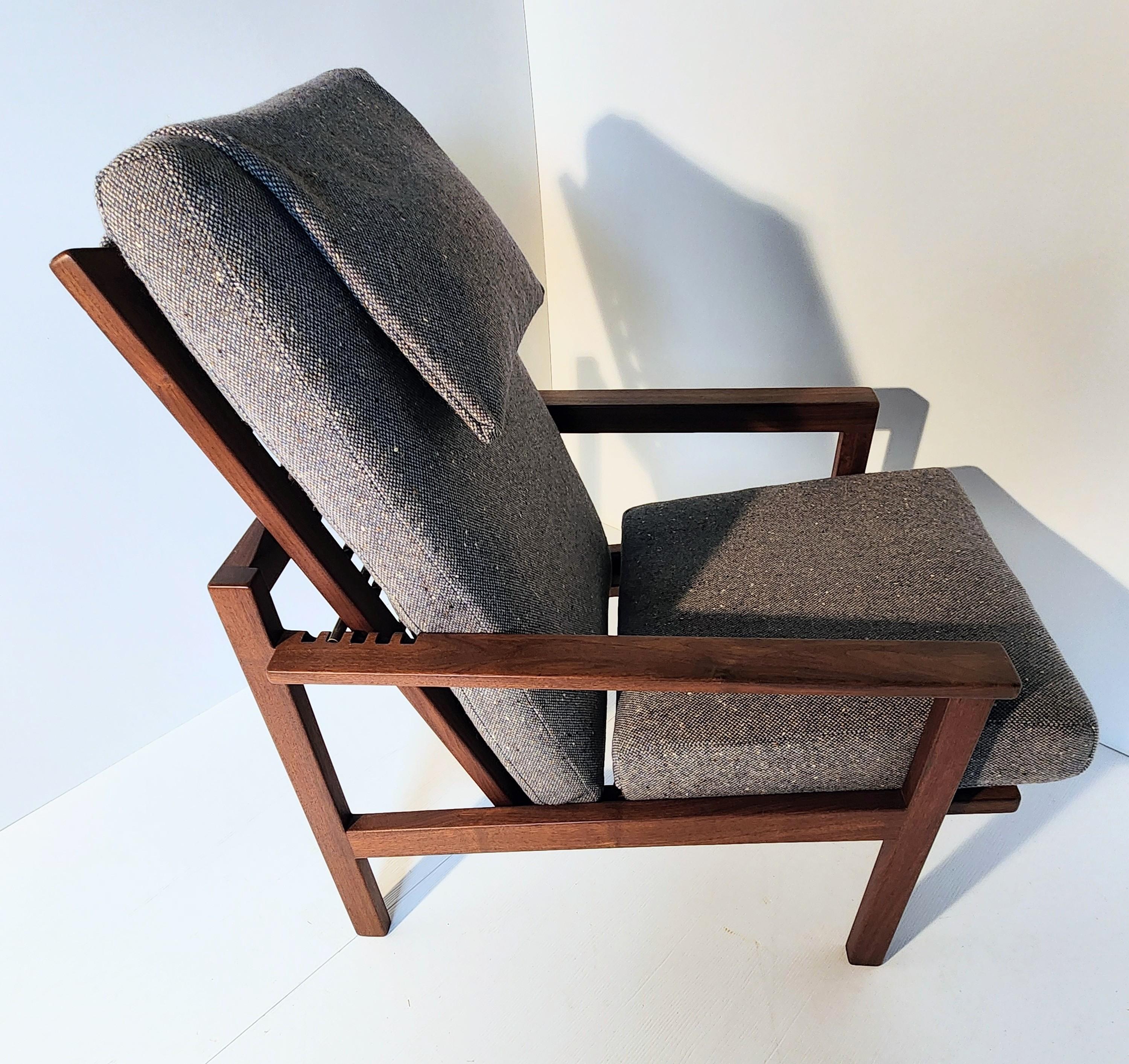 An adjustable lounge chair from one of Ohio's leading furniture craftsman, Arden Riddle. A hand crafted frame of black walnut with cased spring supports makes this a very unusual and comfortable chair. Unlike George Nakashima's use of spindles in