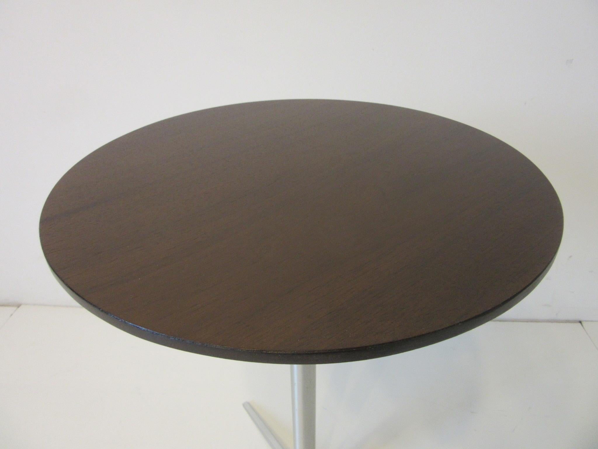 A very slim cigarette / drink side table with round walnut top and brushed aluminum star base retaining the original manufactures label by Thonet NYC. Perfect side table next to that lounge chair or a table for a tight space.