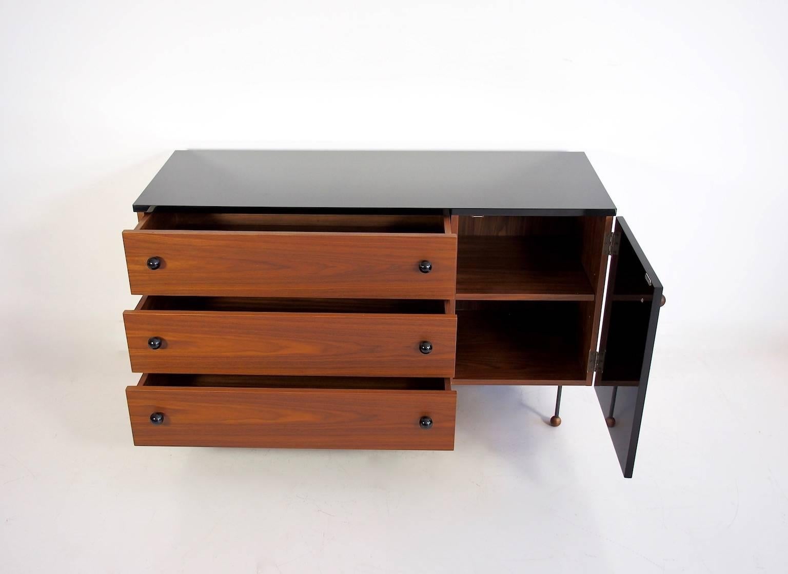 Grossman dresser three, 62-series was originally designed by a Swedish designer Greta Magnusson Grossman in 1952. Sideboard with three drawers and a door behind which are shelves. Black laminate top. Veneered walnut drawers and black-varnished wood