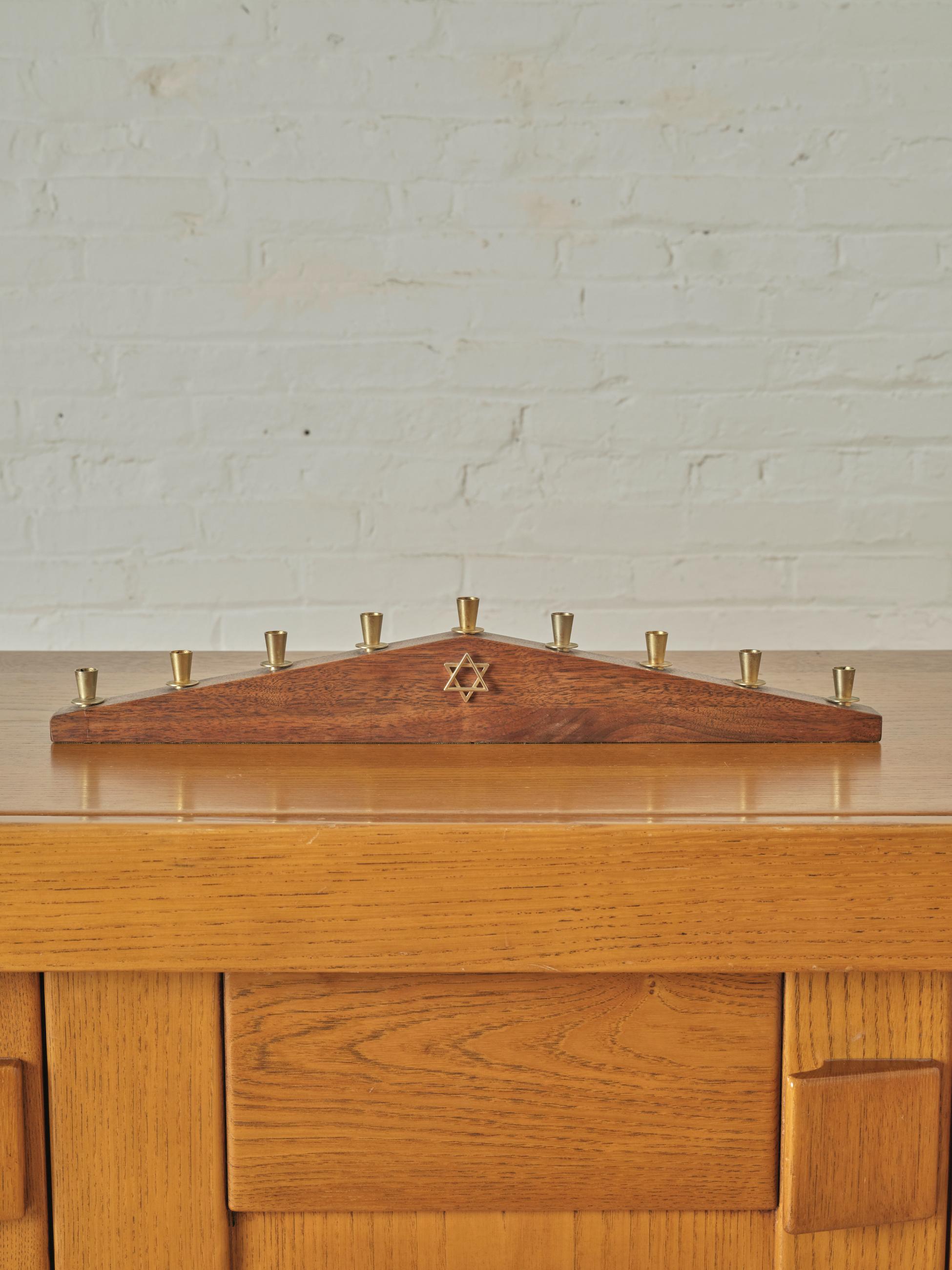 Paul Evans Walnut and Brass Menorah by Paul Evans. Titled the 'Jonathan', this arched angle menorah has a brass Star of David symbol in the center with brass candle holders.

