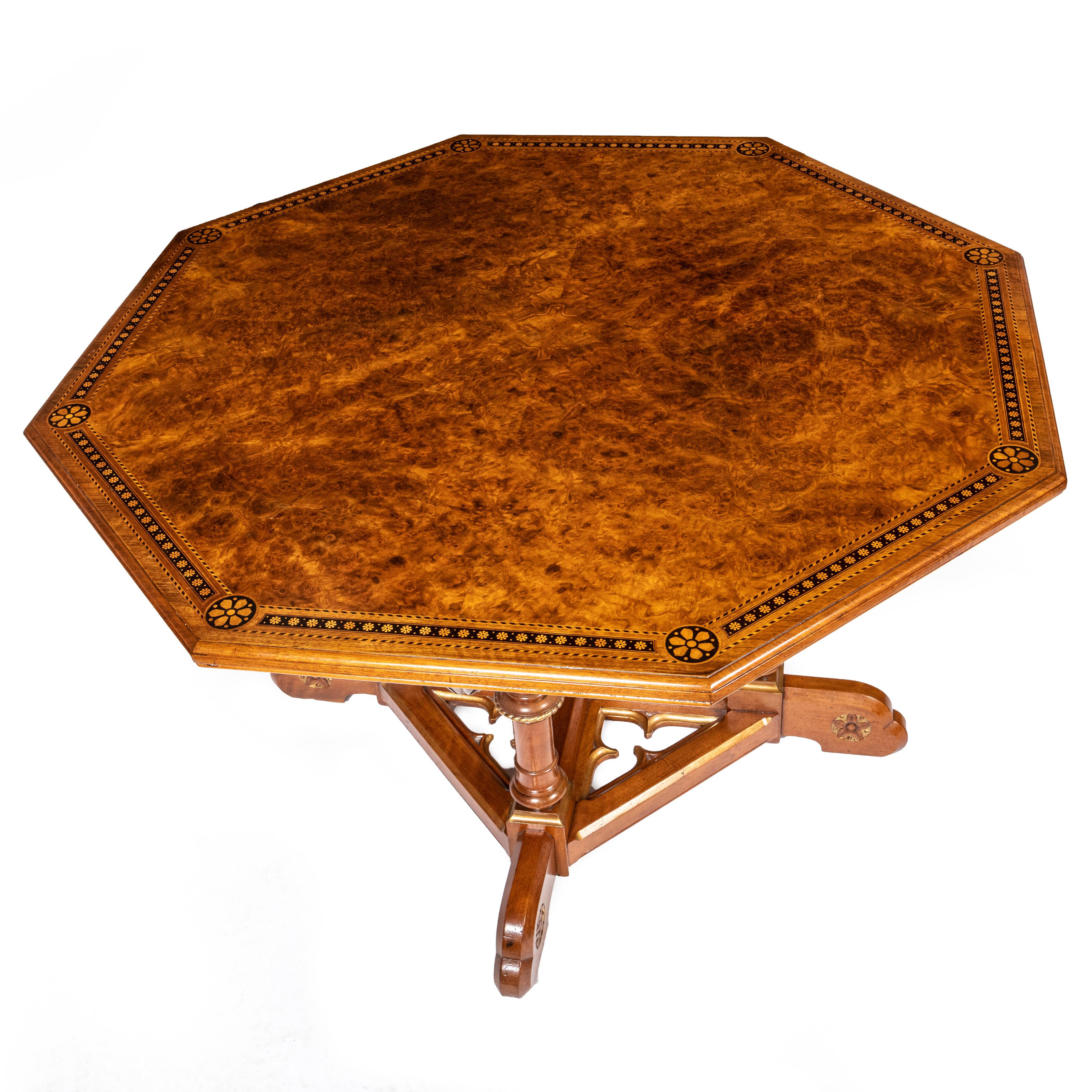 A Fine Octagonal Centre Table.
Walnut and Burr Walnut.
In the manner of Charles Bevan.
The top inlaid with a band of florets in stained wood.
Above leaf carved brackets and ring turned legs.
Above a cruciform base with tracery infill