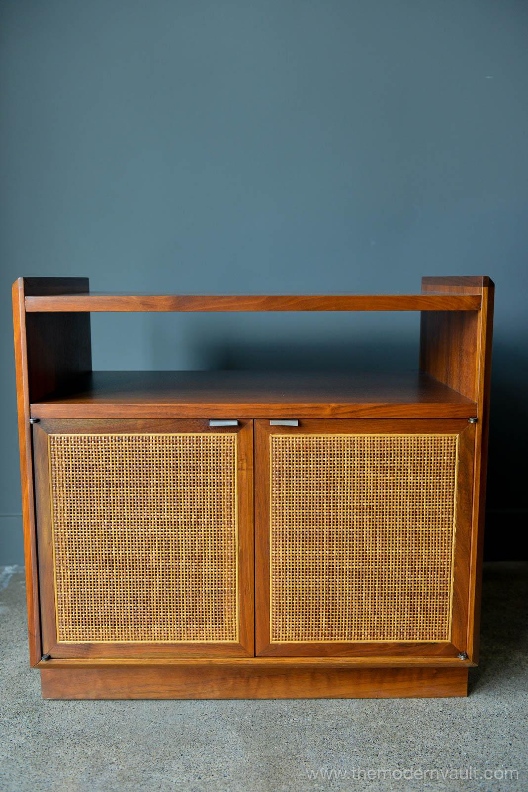 Walnut and cane cabinet or nightstand by Jack Cartwright for Founders, circa 1965. Professionally restored in perfect condition and finished on the reverse. Perfect as a single nightstand or even in a home office for a printer/accessory stand or