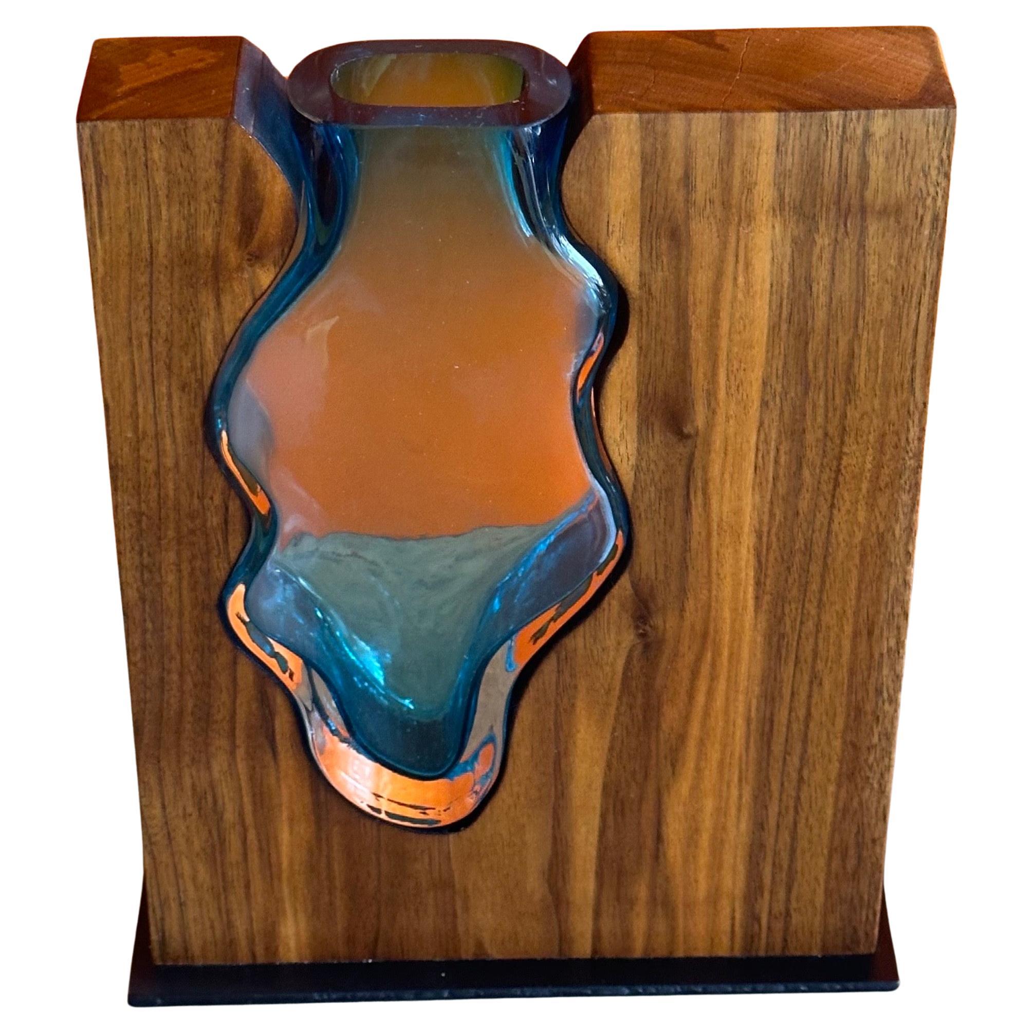 An absolutely gorgeous walnut and emerald art glass vase by Scott Slagerman, circa 2022.  The simple and elegant vase is hand crafted by fitting a custom blown art glass vase into a block of walnut wood.  The piece is in like new condition and