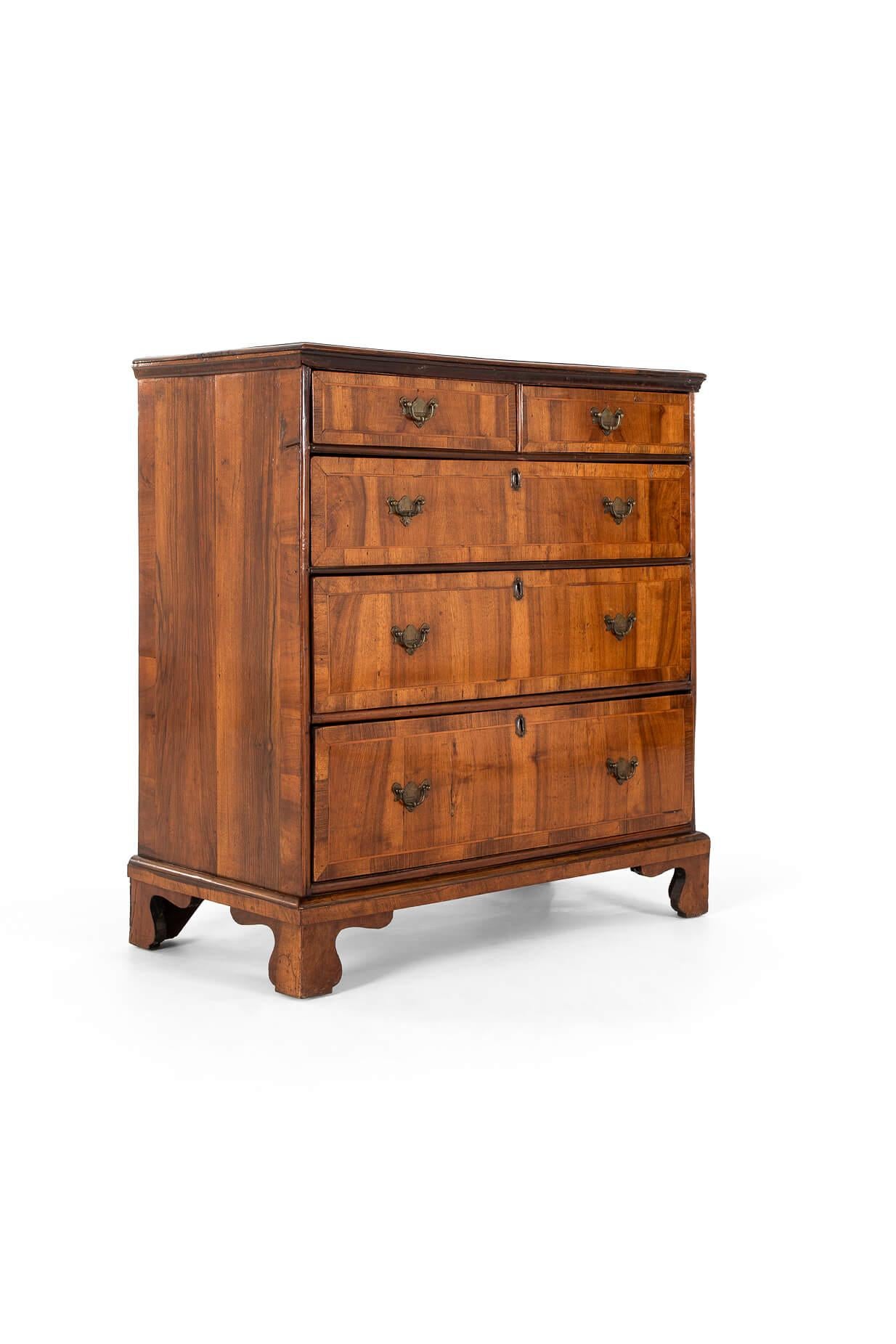 A walnut feather banded chest of drawers in exceptional condition.

Two short over three graduating drawers with brass handles and escutcheons.

Raised on bracket feet with a shapely plinth base.

With superb colour and patination, this is a