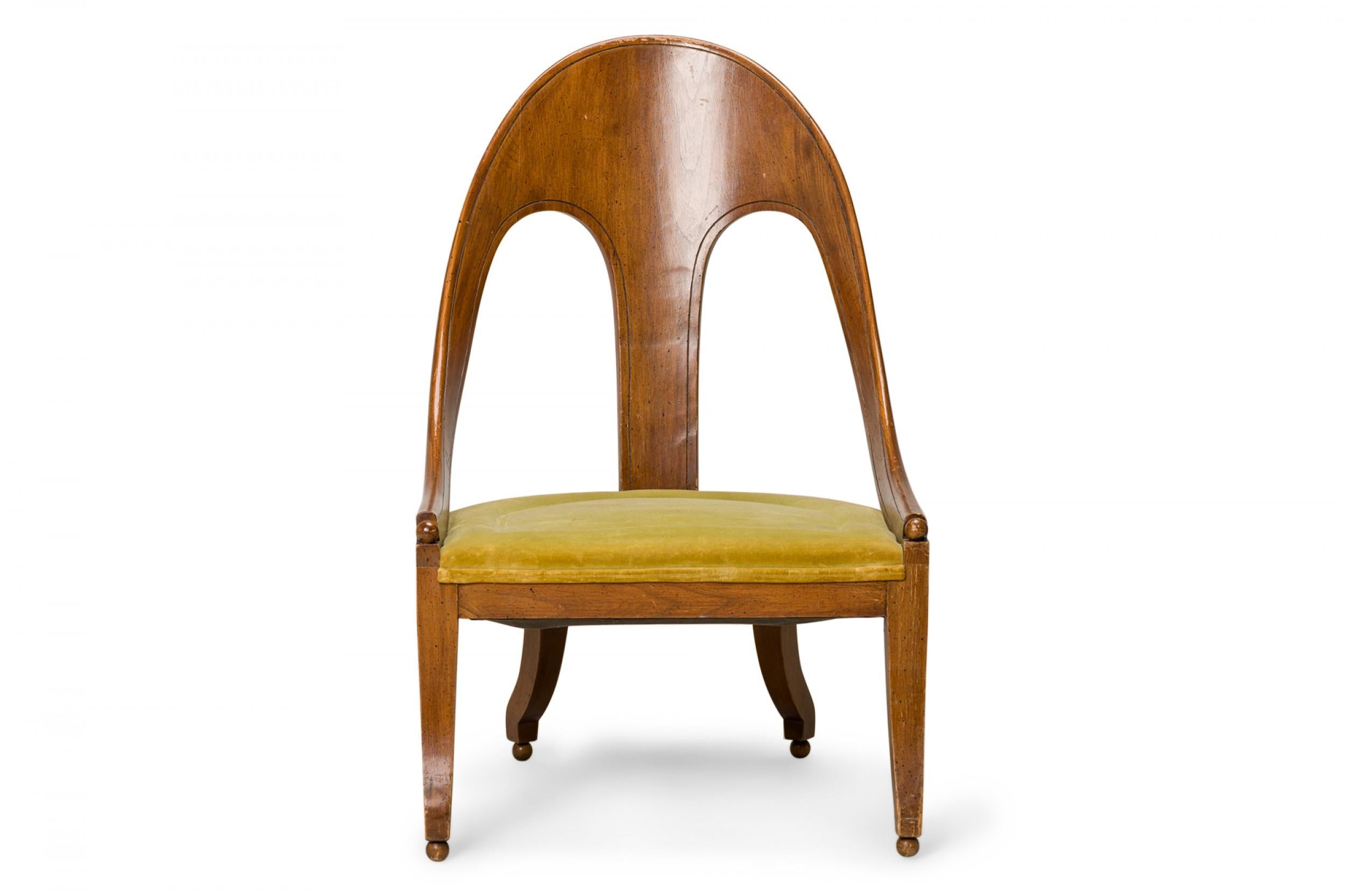American Mid-Century spoon back side / pull up chair with a walnut frame and green velvet upholstered seat, resting on four square curved legs ending in ball feet. (Similar pieces: DUF0427-DUF0431)