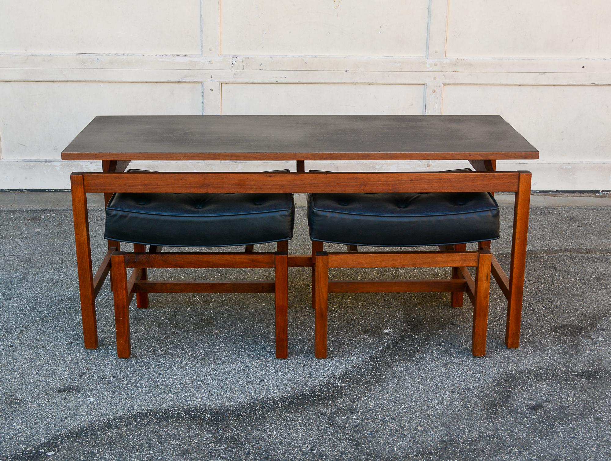 Low table with two stools made by Richbilt Manufacturing. The table and stools are walnut. The table has an inset black laminate top. This set is sometimes attributed to Jens Risom, but he did not design anything for Richbilt. Dimensions listed are