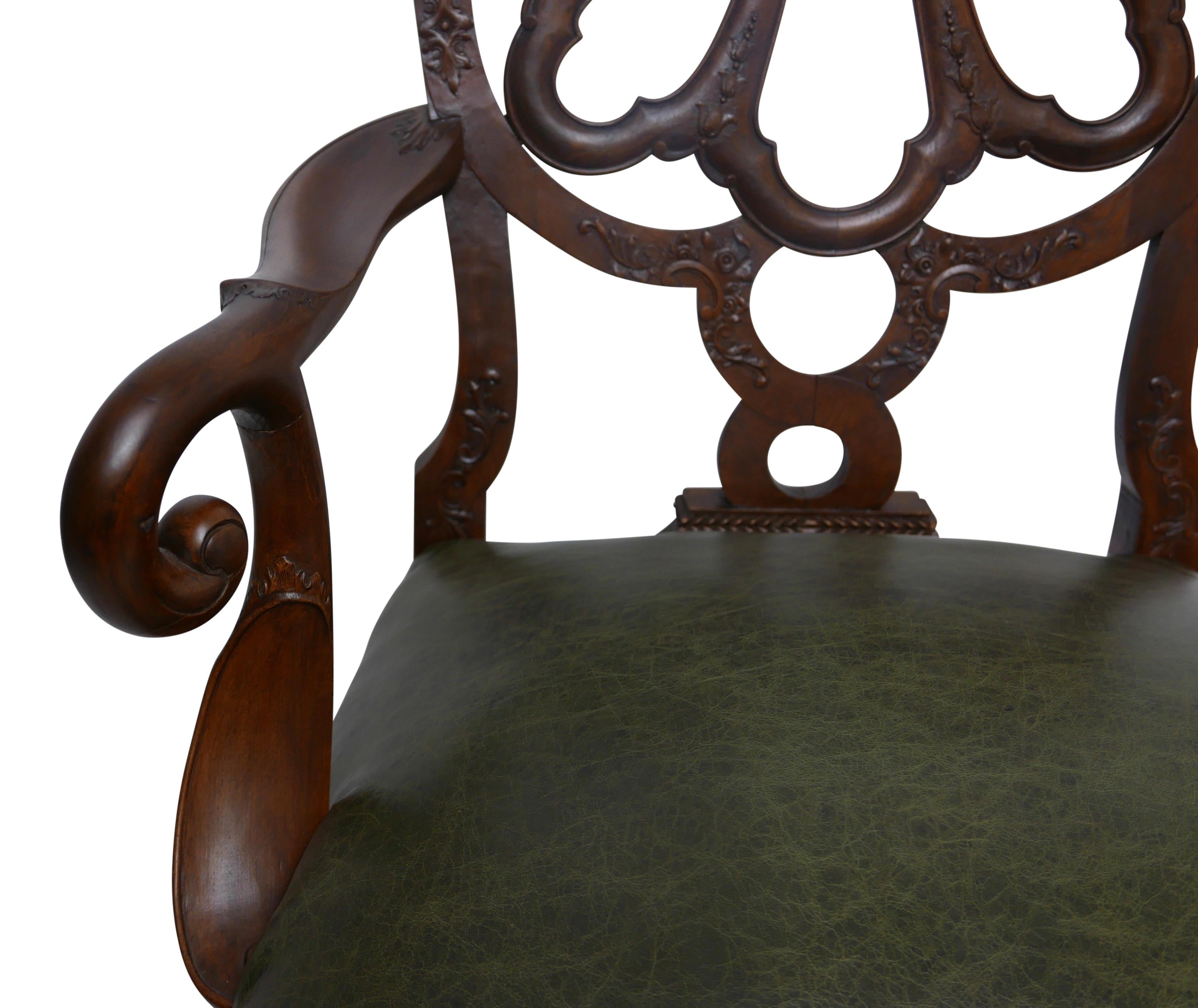 Un fauteuil en noyer de qualité, magnifiquement sculpté et construit à la main, à la manière de Giles Grendey (1693-1780).
Le dos en forme d'anneau est constitué d'une bande ouverte avec un relief décoratif sculpté. Les deux côtés sont flanqués de