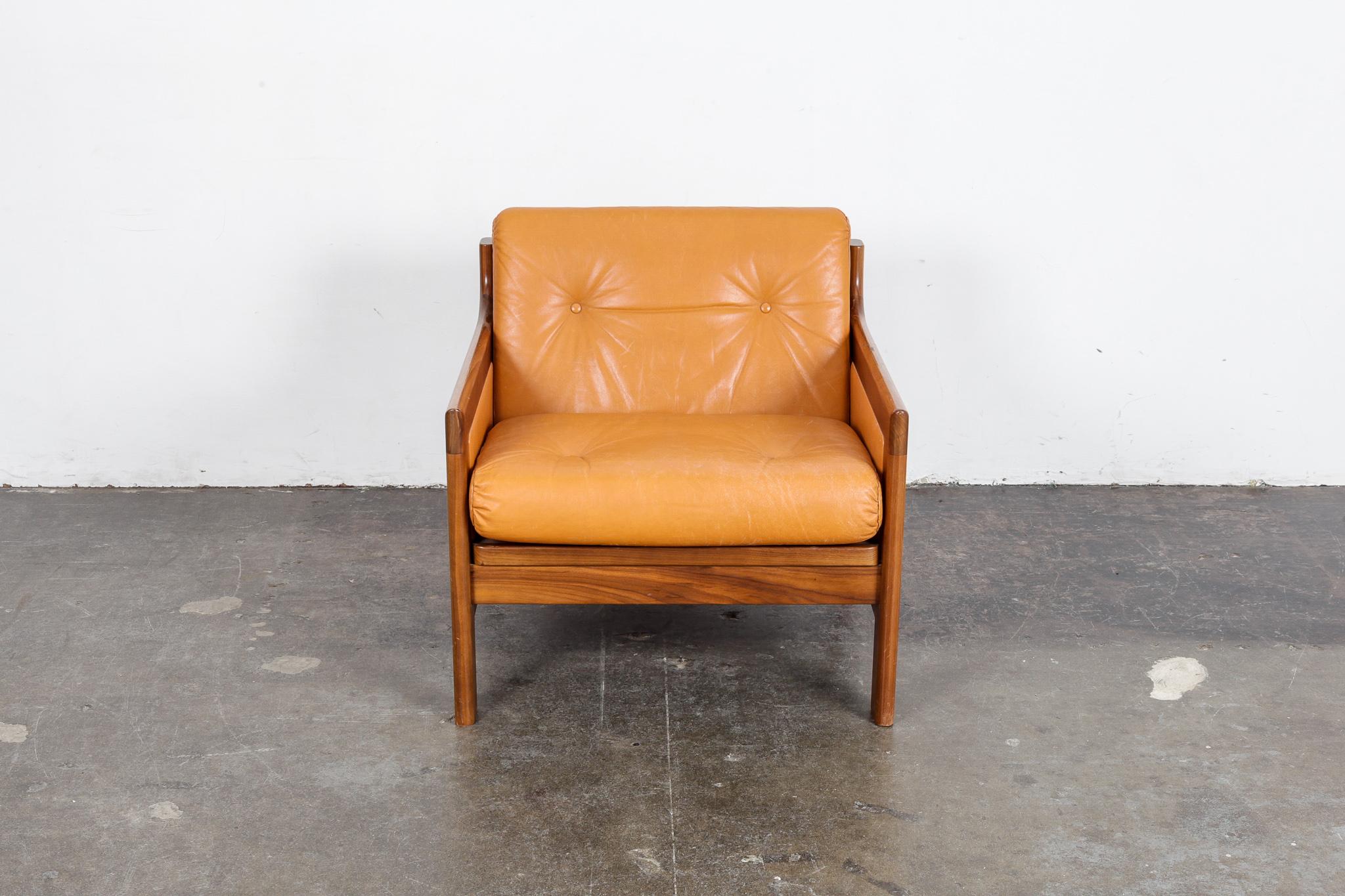Swedish 1960s walnut lounge chair in marigold leather designed by Karl Erik Ekselius for OPE Mobler, with button tufted back and seat cushions.
