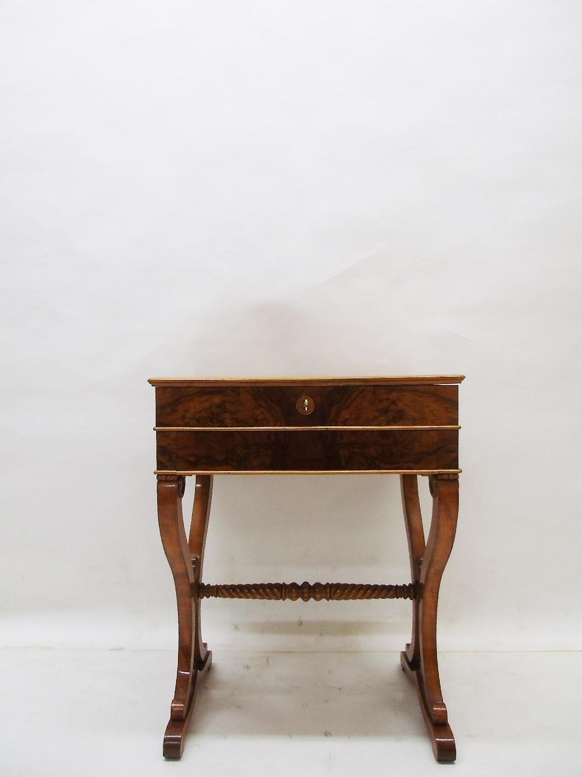 Petite and wonderful Biedermeier sewing table or elegant side table from southern Germany, 1830s. As a beautiful example of antique Biedermeier furniture it convinces with its bookmatched walnut veneer on the tabletop and the exclusive maple