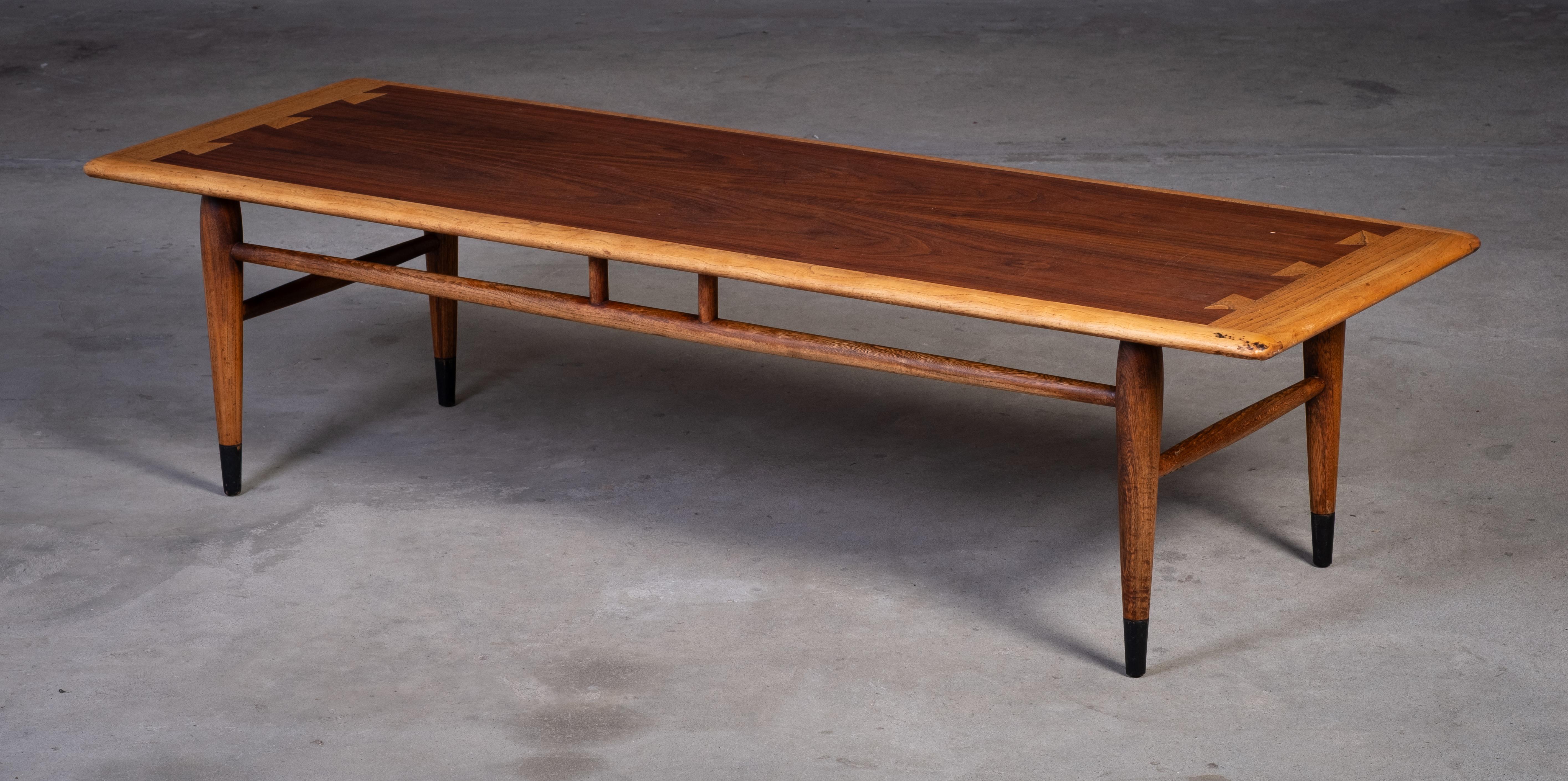 Elegant mid-century coffee table designed by Dutch designer Andre Bus and produced by Lane Acclaim in the 1960s. Crafted in walnut and oak, the table features beautiful details that highlight its timeless Scandinavian-inspired design. In excellent