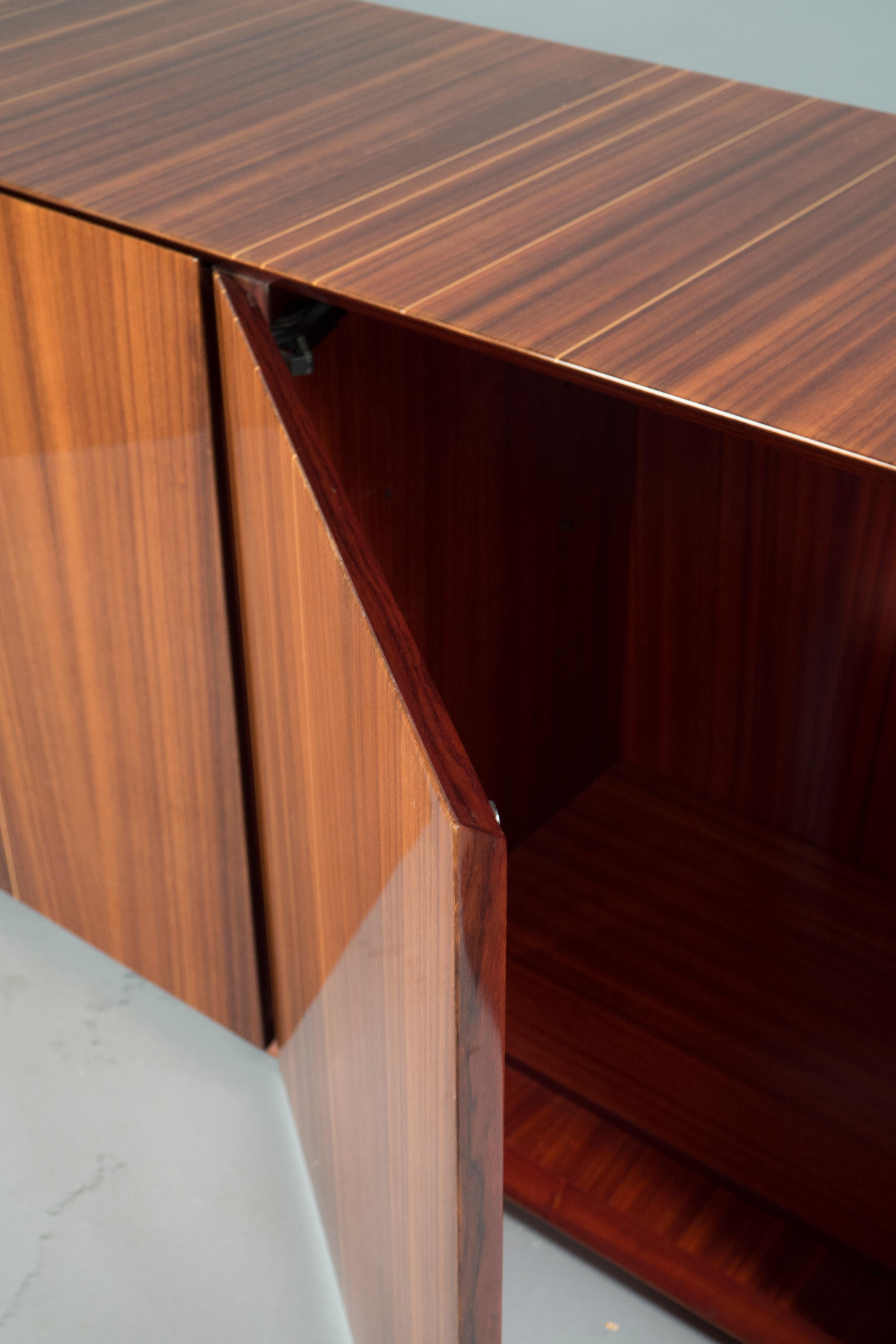 Walnut veneered sideboard with partial sycamore inlay, the interior features one shelf per section.
 