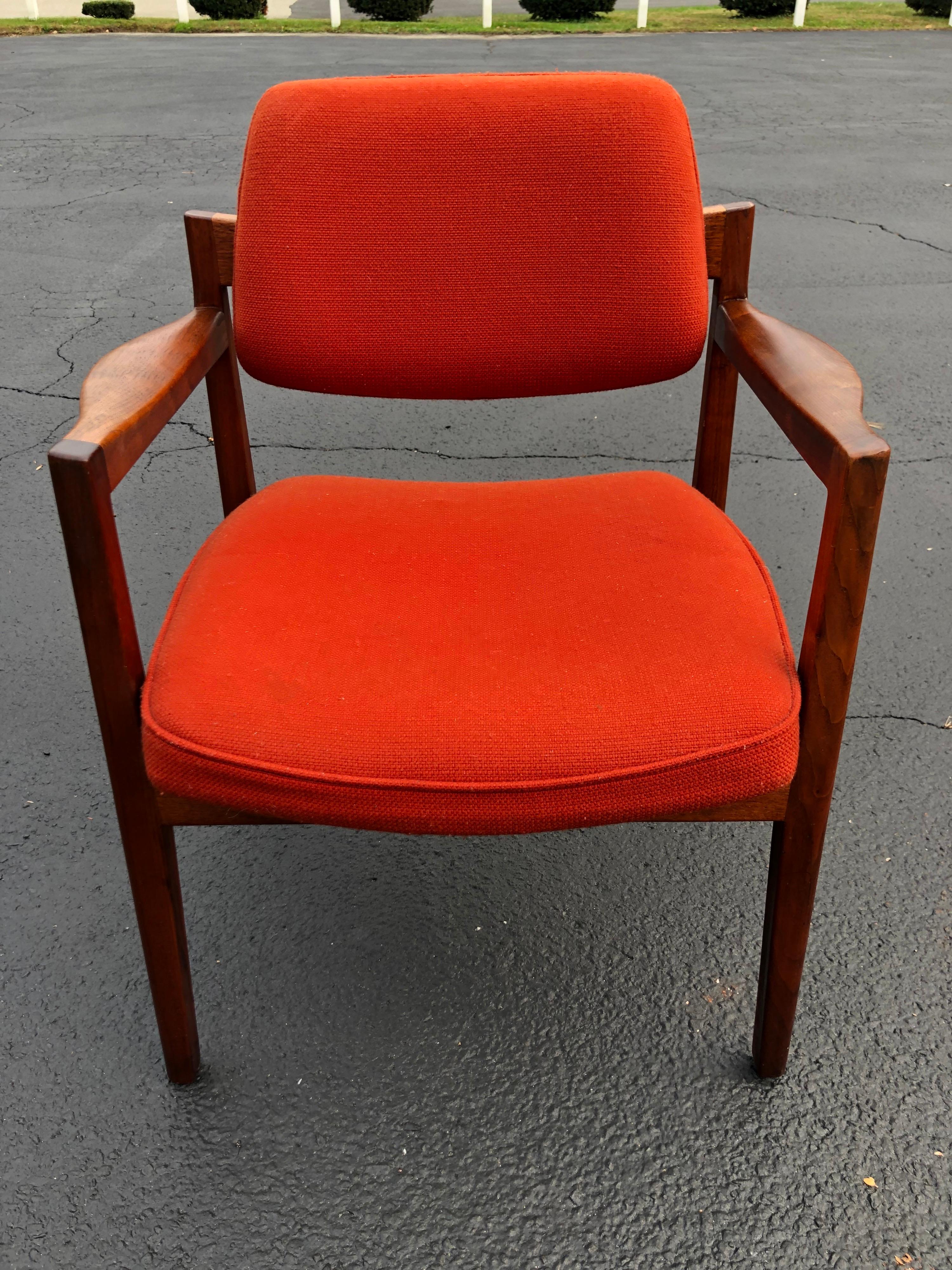 Walnut armchair in the style of Jens Risom. Classic Danish modern lines with rich patina to the curved wood. Original mid Century upholstery is a gorgeous original burnt orange rust hopsack. Amazing lines to this chair. There is a hardening to the