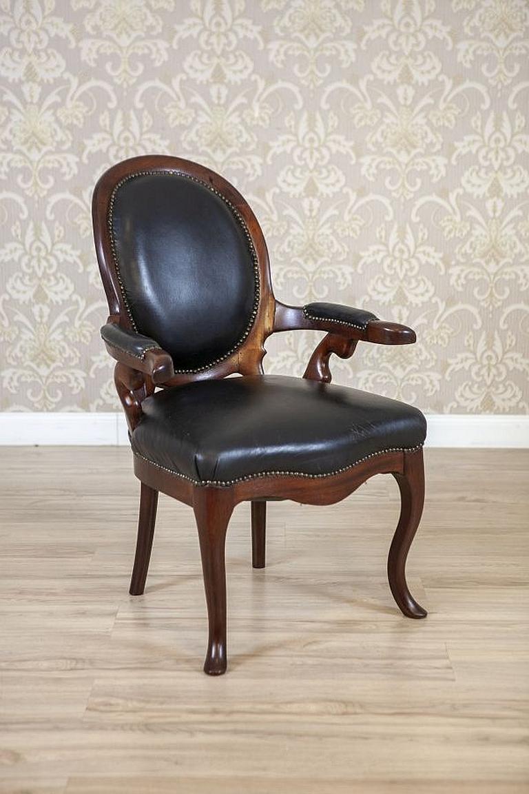 Walnut Armchair From the Late 19th Century in Black Leather

We present you this walnut armchair with upholstered armrests, seat and medallion-shaped backrest. The legs are bent. The armchair is padded with original leather, with delicate traces