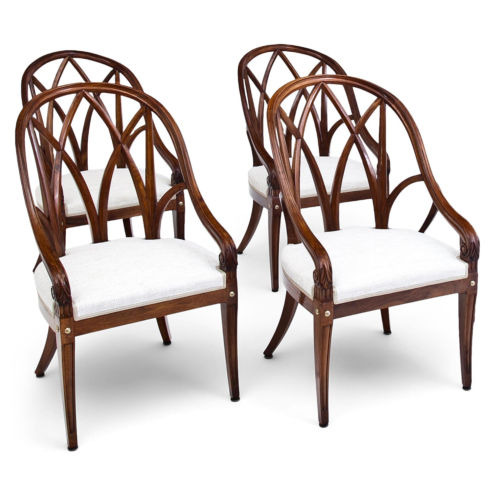 Set of 12 elegant French armchairs with exquiste, curved backrests out of solid walnut. The armrests end in volutes and rest upon the tapered front legs. These are decorated with round brass rivets and are fluted. The backsides show each a small