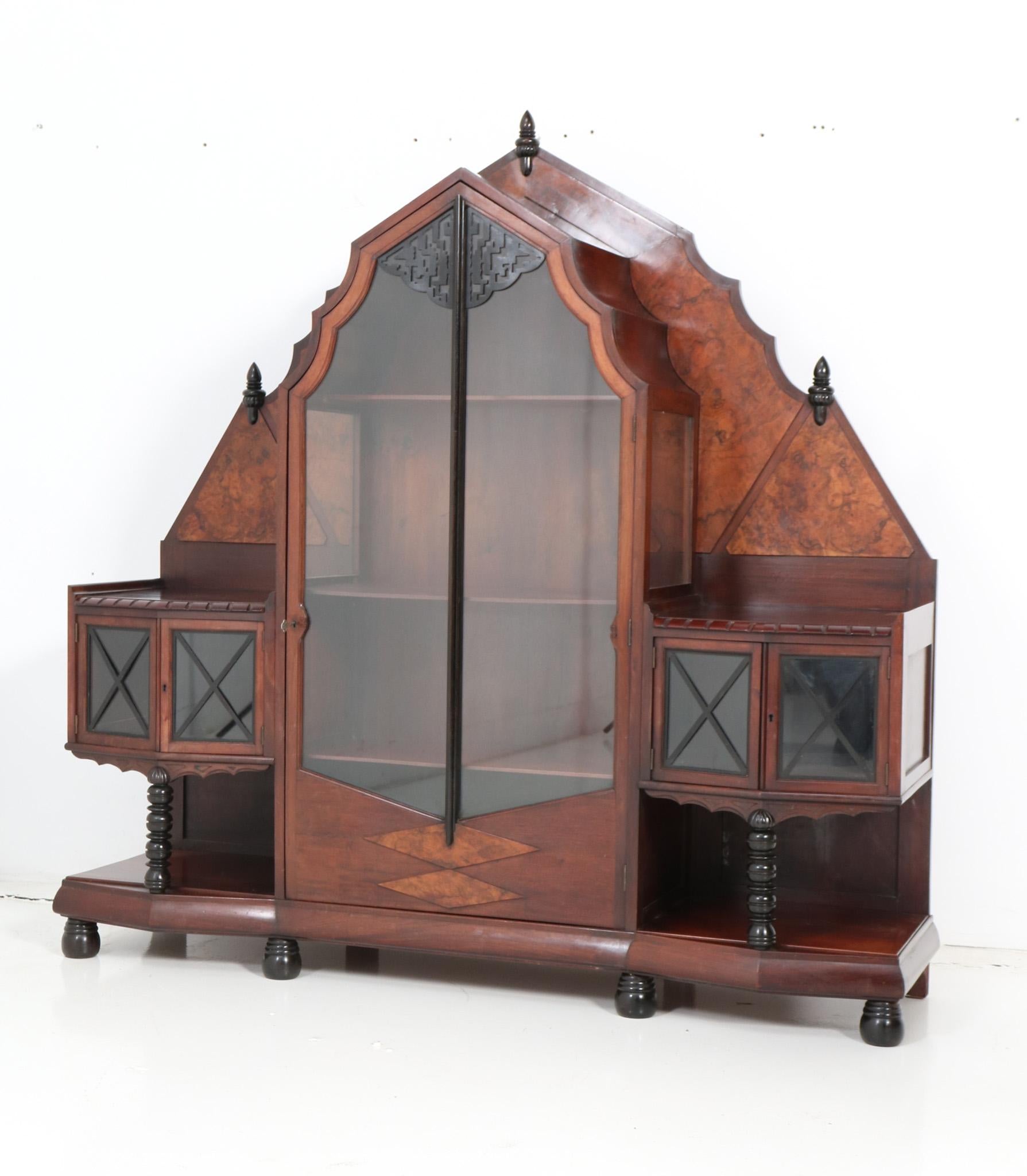 Magnificent and ultra rare Art Deco Amsterdamse School vitrine or China cabinet.
Design by Max Coini Amsterdam.
Striking Dutch design from the 1920s.
Solid walnut base with original burl walnut veneer and original black lacquered elements.
Three