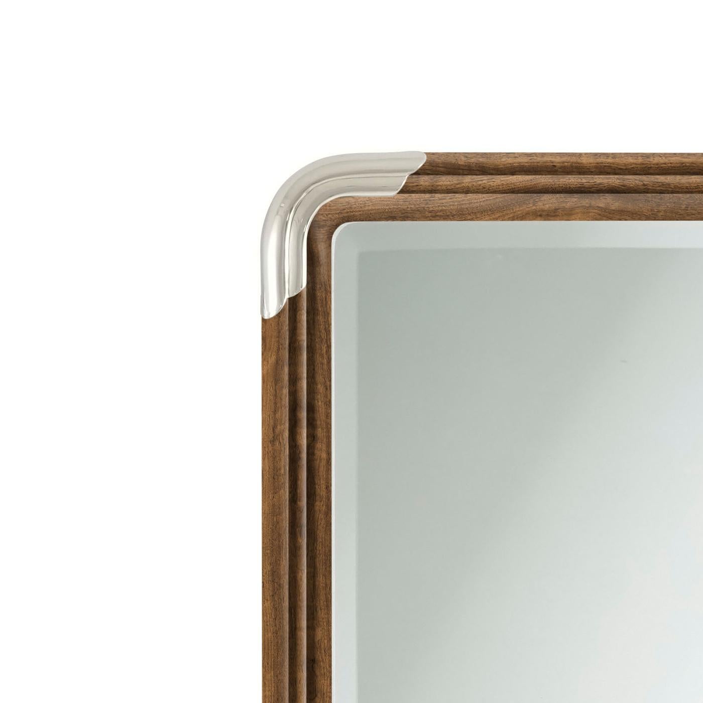 Mirror beautifully embodies early 1900s design ideals with its clean lines and elegant, rectangular shape. Framed in exquisite figured walnut with a molded edge, this mirror showcases timeless craftsmanship and understated sophistication. Its