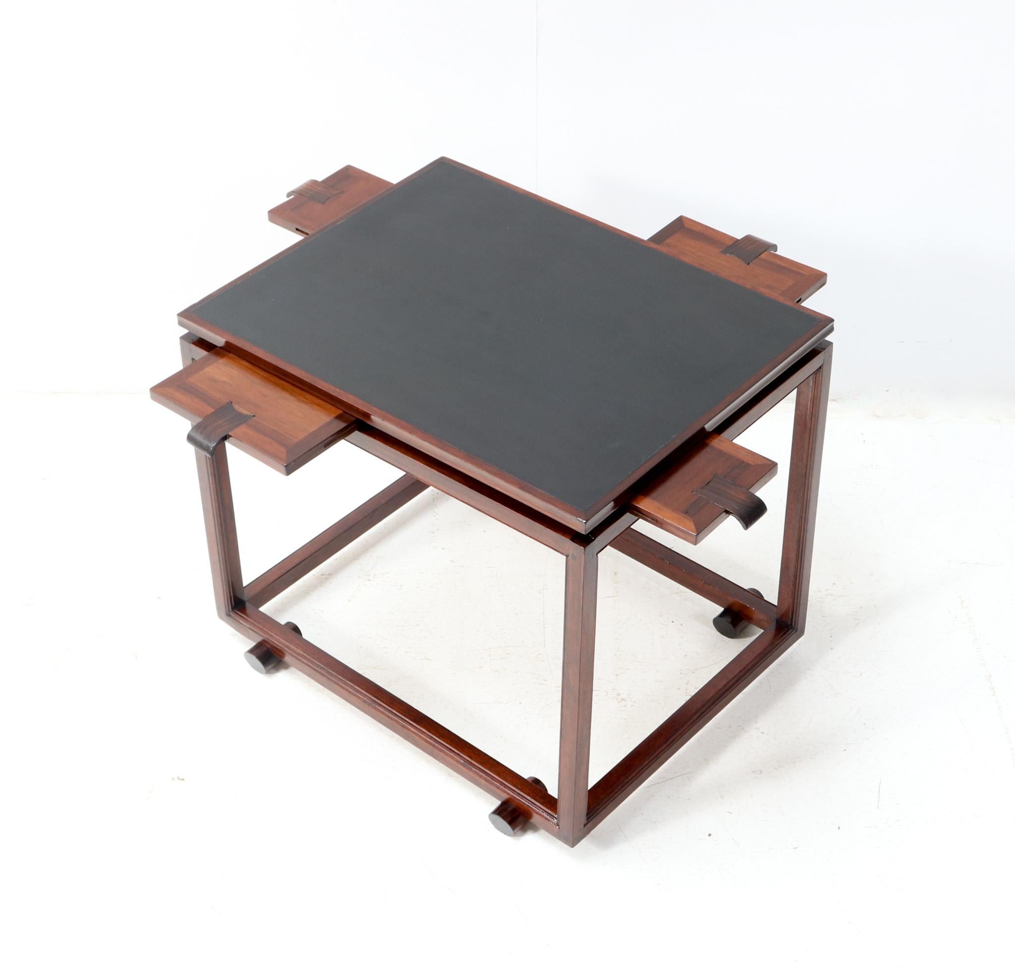 Magnificent and ultra rare Art Deco Modernist game table.
Striking Dutch design from the 1920s.
Solid walnut base with original black faux leather top.
Four original pull-out shelves with original macassar ebony handles.

In very good refinished