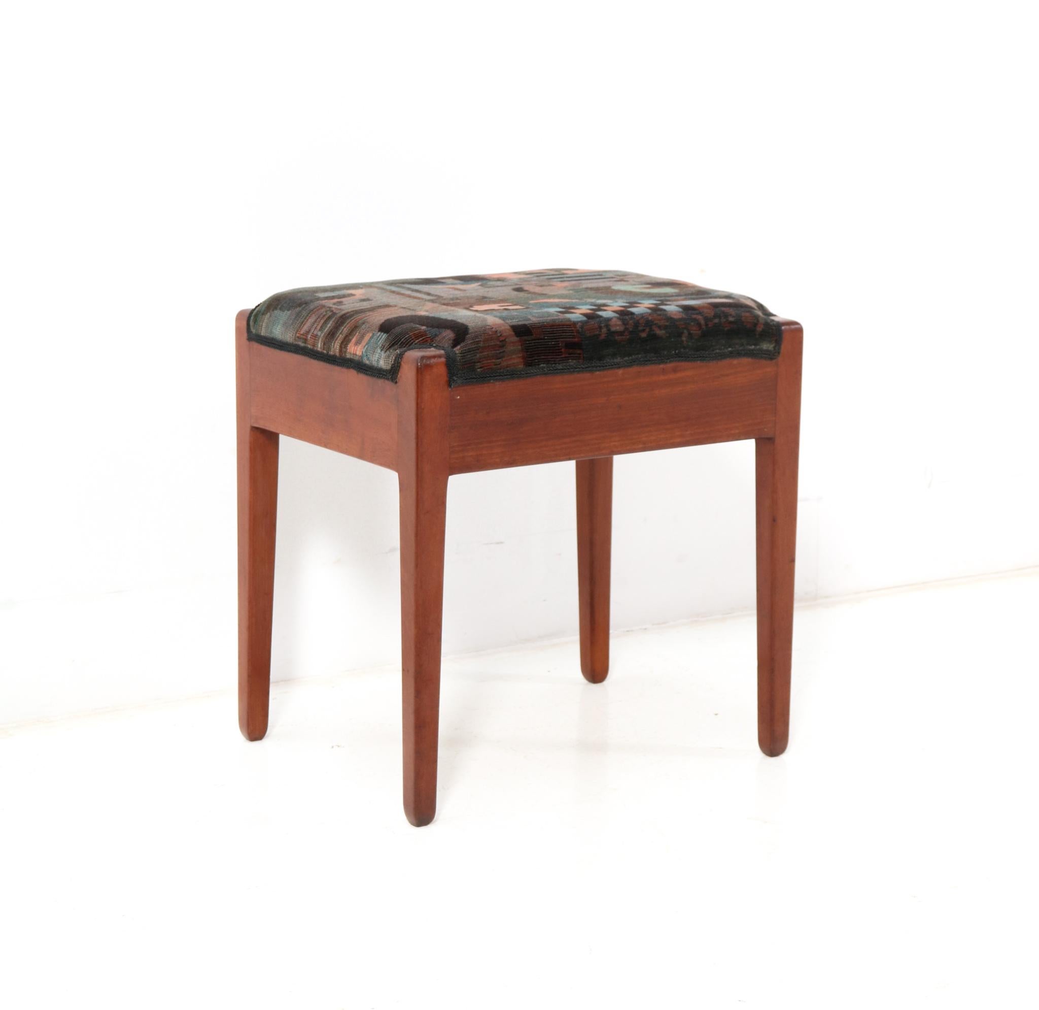 Stunning and rare Art Deco Modernist stool.
Design by L.O.V. Oosterbeek.
Striking Dutch design from the 1920s.
Solid walnut base and re-upholstered with a multicolored Art Deco fabric.
This wonderful Art Deco Modernist stool by L.O.V. Oosterbeek