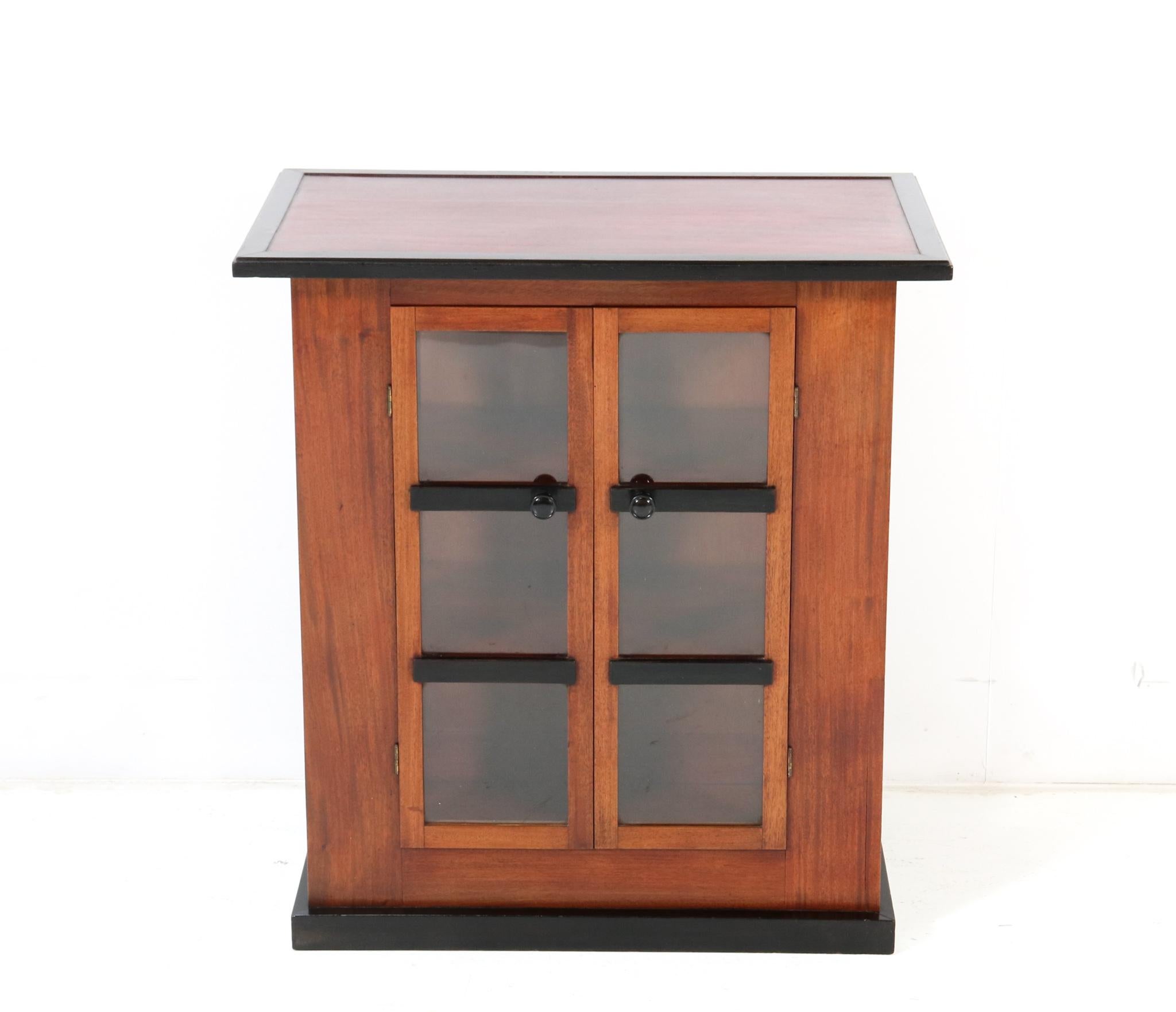 Magnificent and rare Art Deco Modernist tea cabinet or serving cabinet.
Design by Jan Brunott.
Striking Dutch design from the 1920s.
Solid walnut and original black lacquered knobs on the two doors.
Original black lacquered elements and original