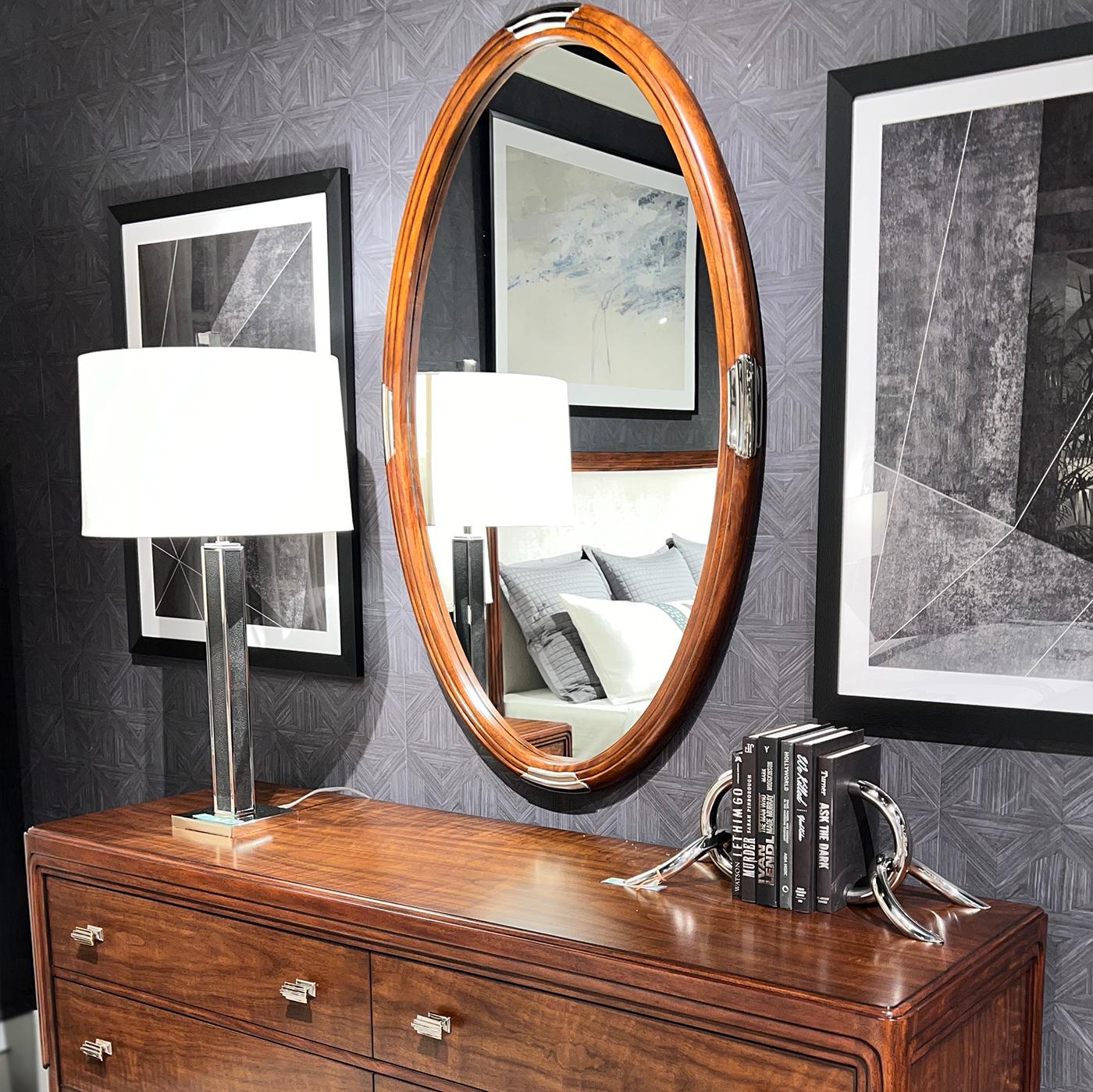 Le miroir incarne magnifiquement les idéaux du design du début des années 1900 avec ses lignes épurées et sa forme élégante et arrondie. Encadré de noyer figuré exquis avec un bord moulé, ce miroir témoigne d'un savoir-faire intemporel et d'une