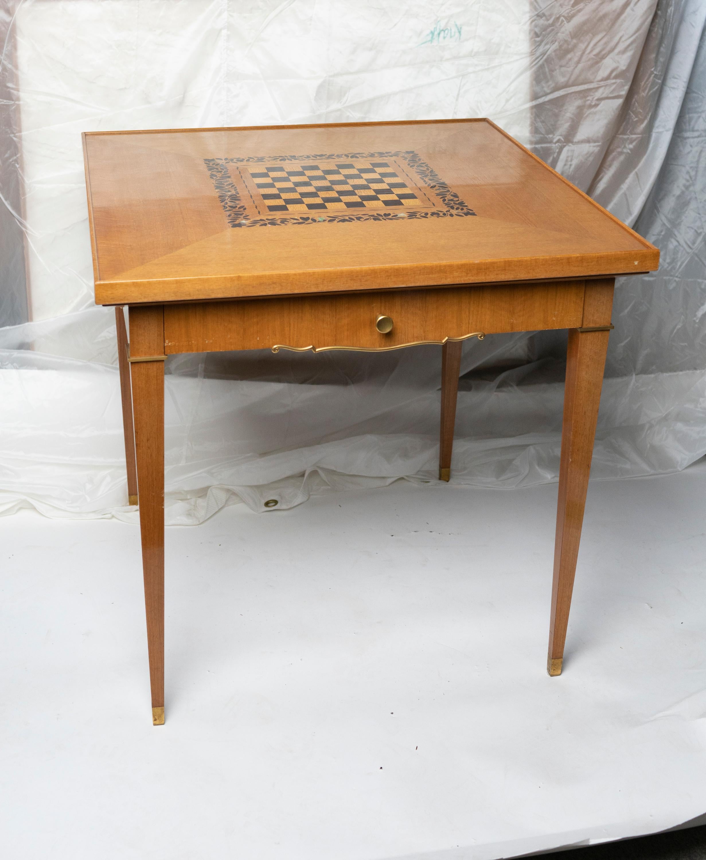 Walnut game table by Jules Leleu, with an inset chest board ebony wood and mother of pearl. The reverse side is made in tooled black and silver leather resting on gilded brass feet signed: Bearing sticker: 