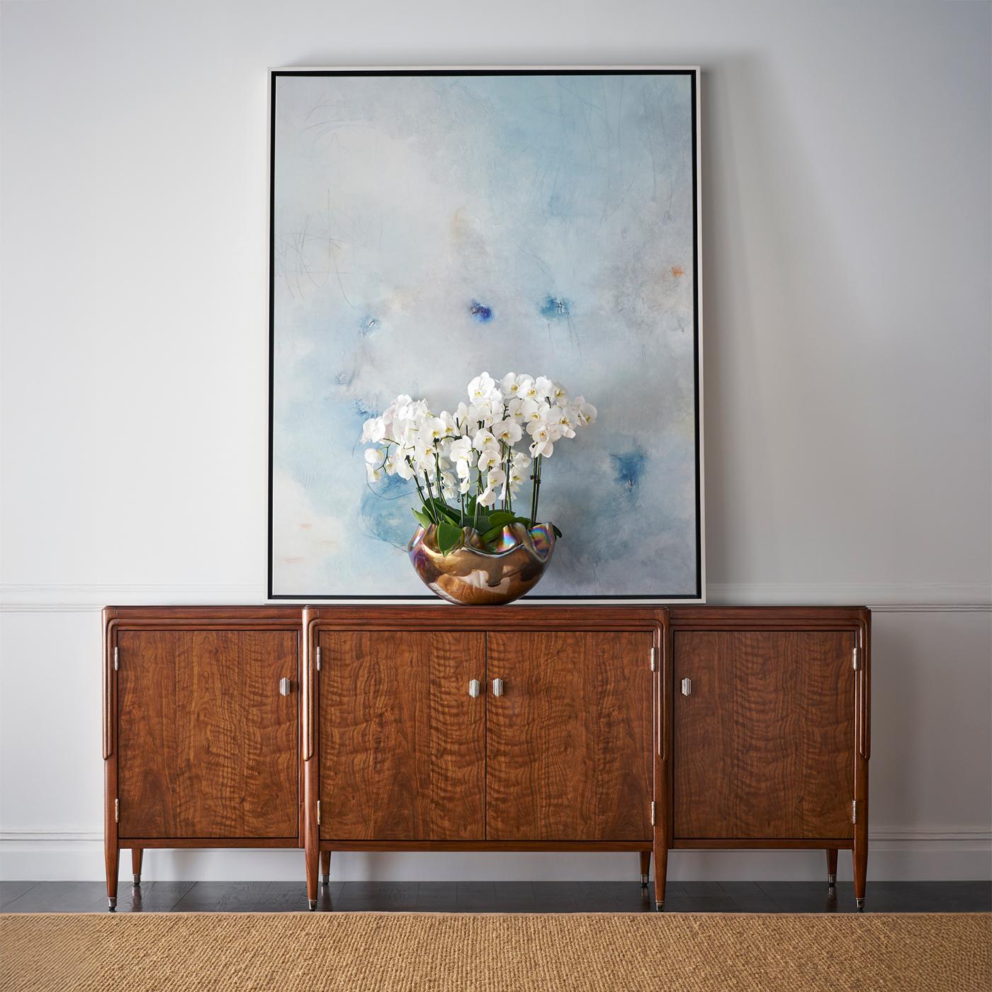 Realizzato in pregiato legno di noce, le sue ricche venature e il sottile motivo decorativo creano una dichiarazione di sobria opulenza. Le gambe sapientemente affusolate e i sottili dettagli di modanatura ne esaltano la silhouette, mentre