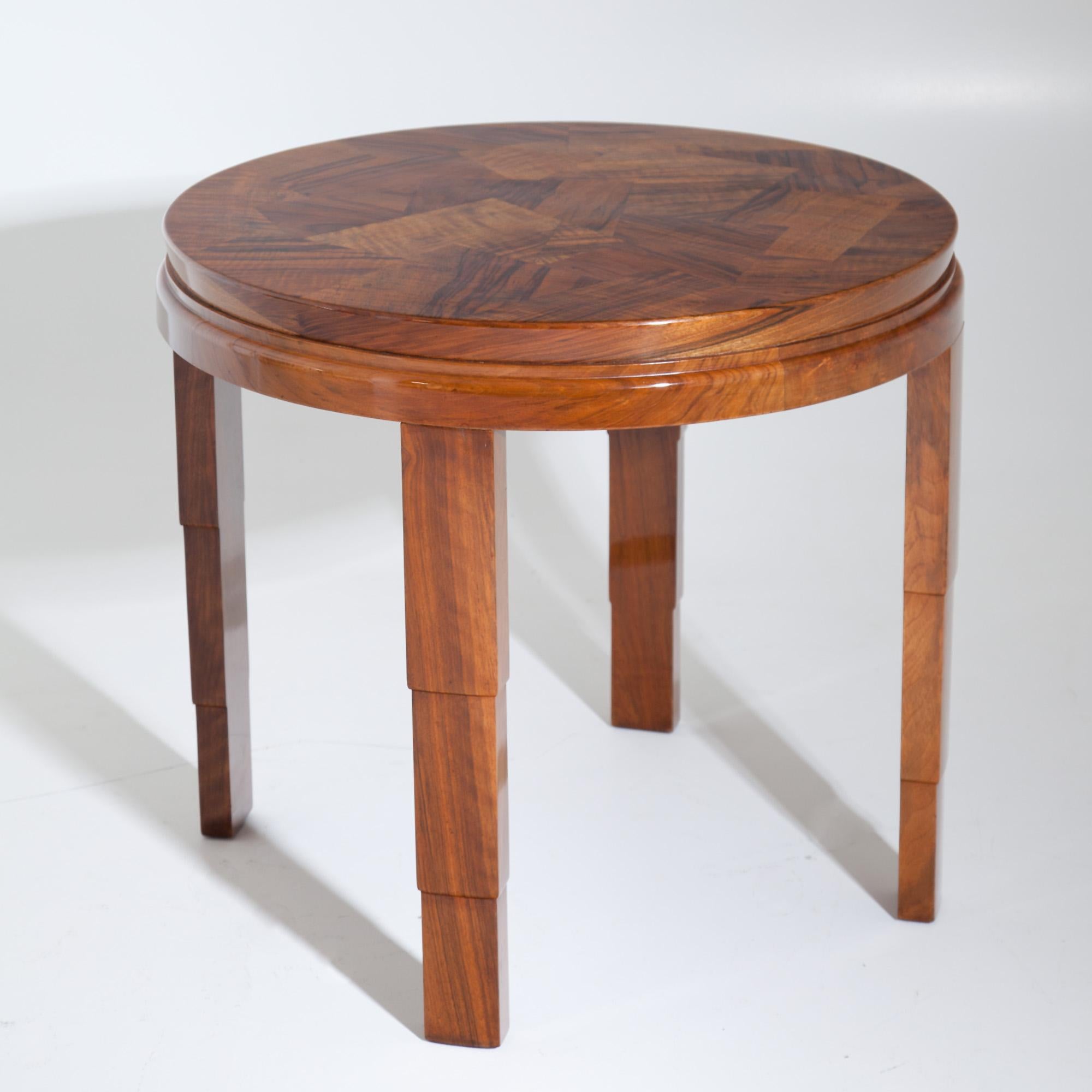 Round Art Deco table with asymmetrical walnut veneer on stepped legs. Stamped on the underside G. Weber FILS & Cie, Genève.