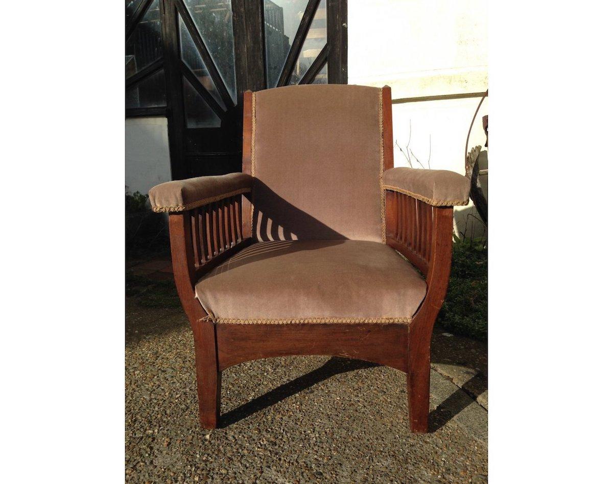 A super quality English Arts and Crafts upholstered Walnut armchair with subtle Pyramidal top details gentle curving out of the arms with slatted supports below, give it a generous seat and rather comfy, with sweeping aprons on all sides below,