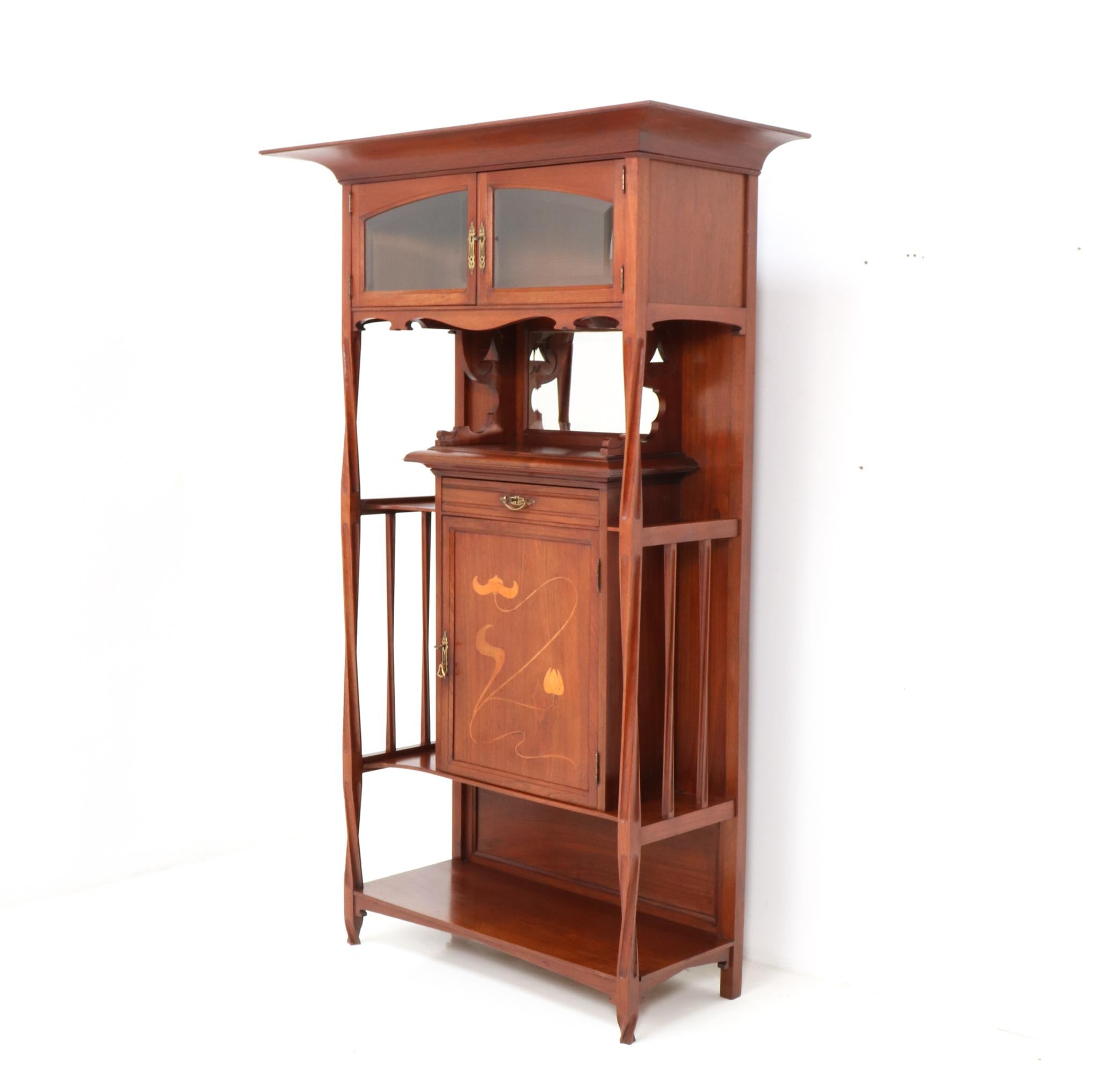 Magnificent and rare Arts & Crafts Art Nouveau cabinet.
Design by Royal H.P. Mutters & Zoon Den Haag.
Striking Dutch design from the 1900s.
Solid American walnut with original brass handles and original inlay.
Original beveled glass in the two