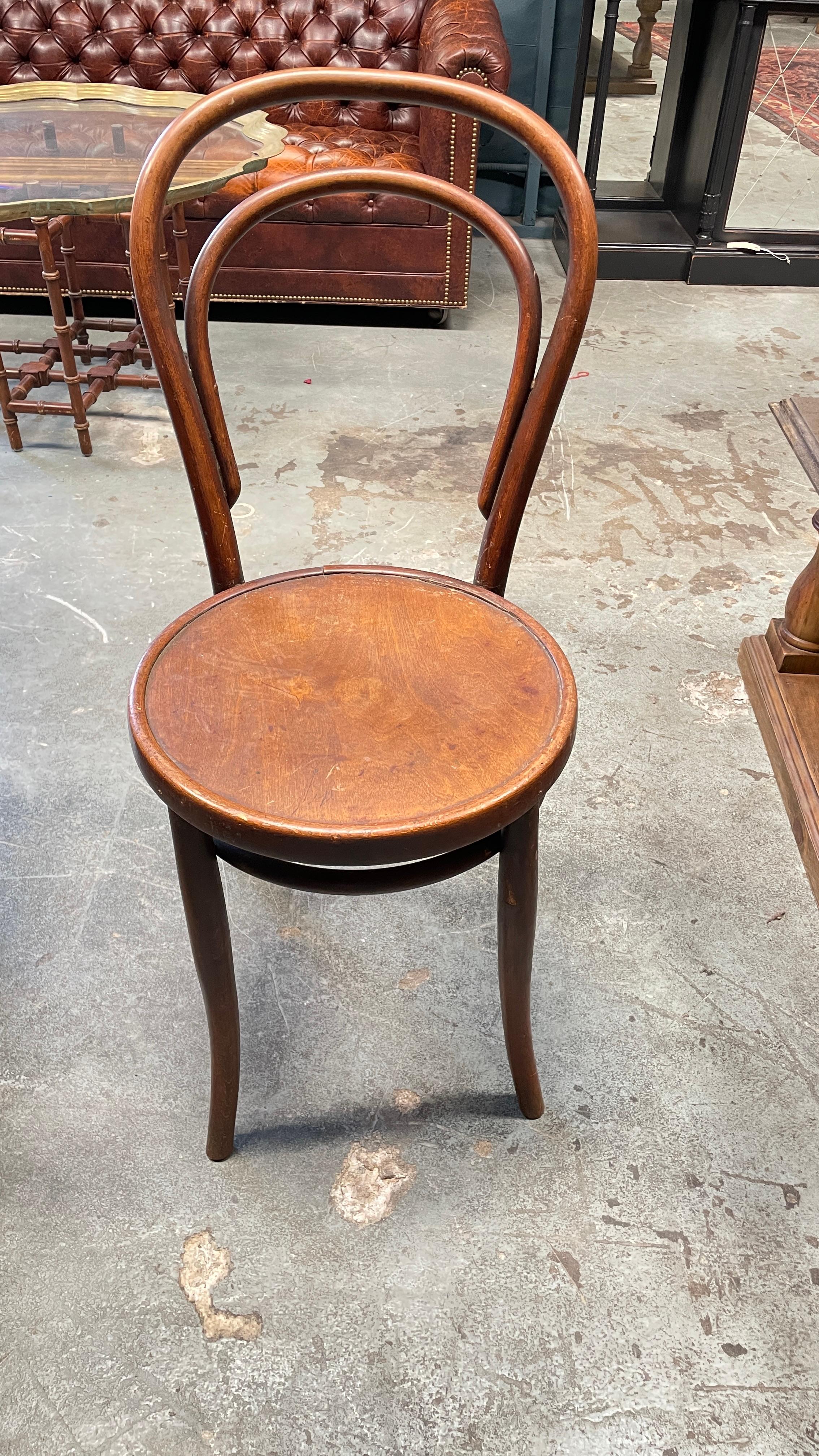 Antique Thonet-style walnut bentwood dining chairs with splayed hairpin legs and two distinct curves making up the back of the chair. This sturdy chair boasts a rich walnut finish.

