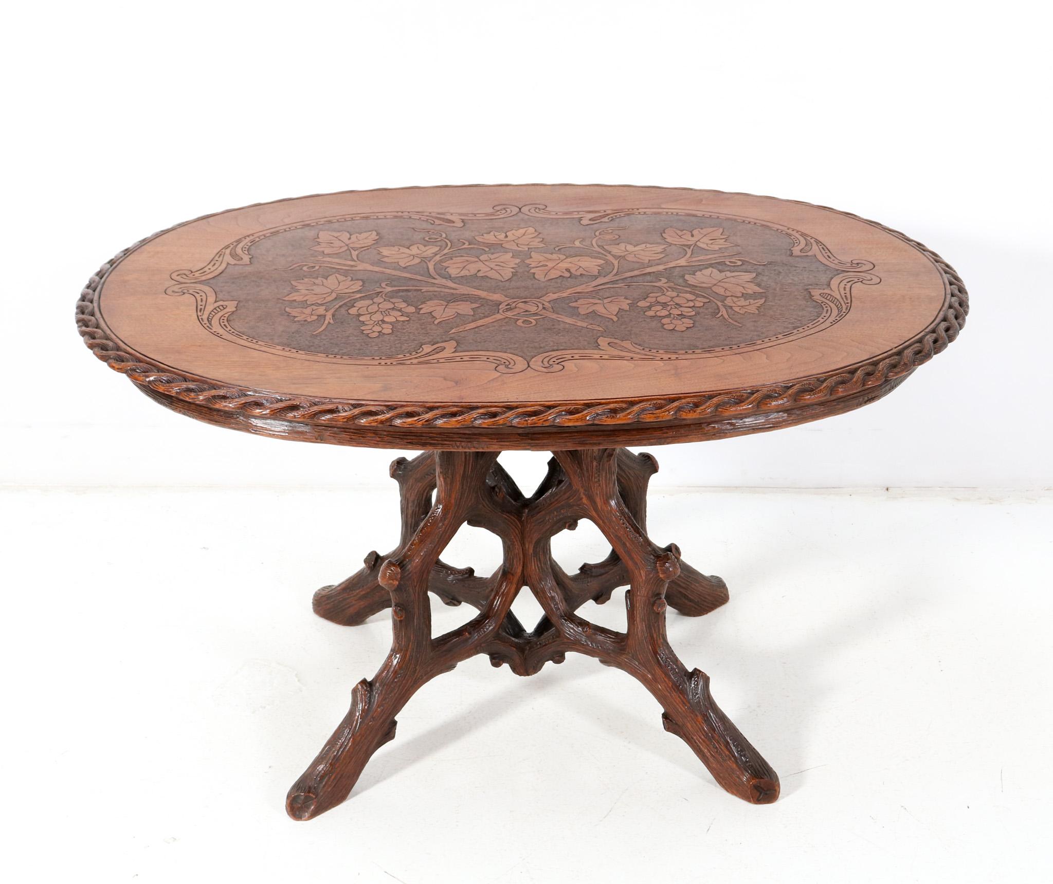 Magnificent and ultra rare Black Forest center table. Design by Matthijs Horrix for the famous Dutch cabinet makers Horrix Den Haag. Striking Dutch design from the 1880s. Solid hand-carved walnut base with original hand-carved and inlaid top. This