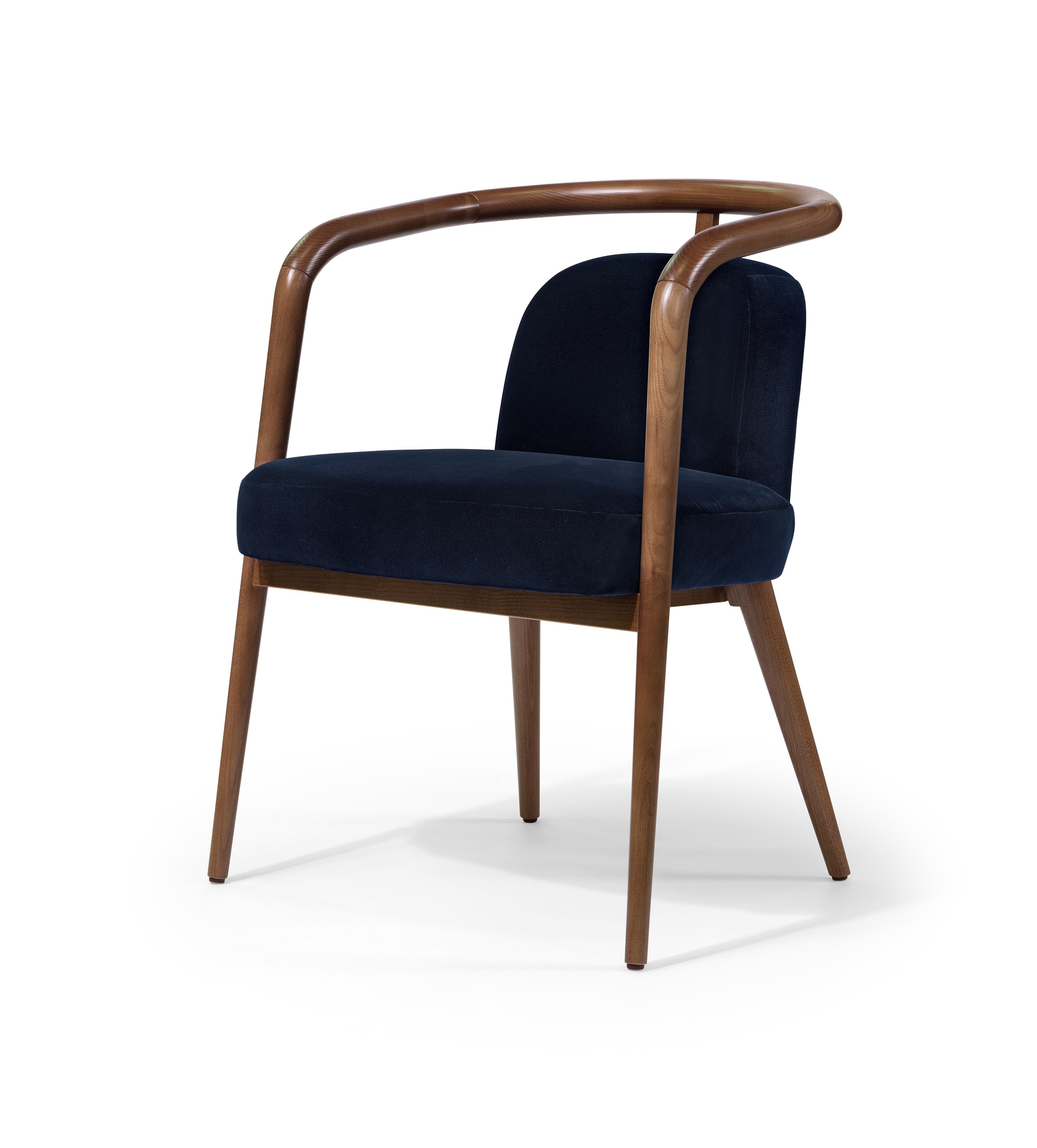 The Essex Armchair is a beautiful fusion of walnut wood and velvet upholstery, offering both luxury and comfort in a sleek, modern design. With its clean lines and refined proportions, it adds a touch of sophistication to any space, from living