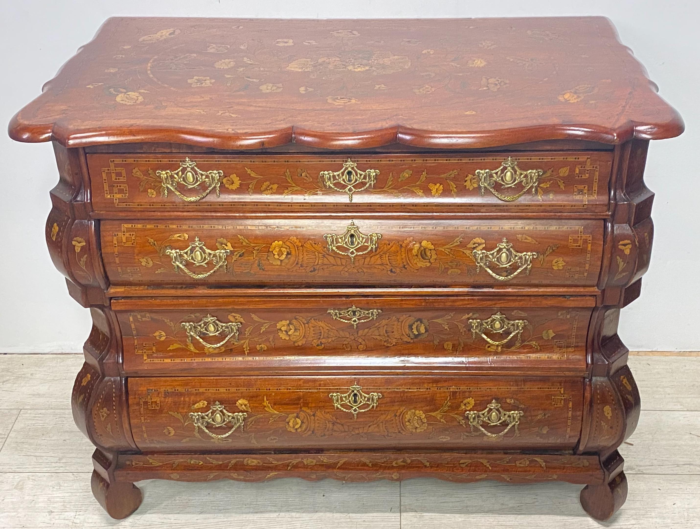 Curvaceous four drawer Dutch commode with satinwood and fruitwood inlaid foliate motif, most showing the original hand tinted green leaves.
Beautifully constructed in walnut veneer over solid oak, with an excellent color and patination. 
18th
