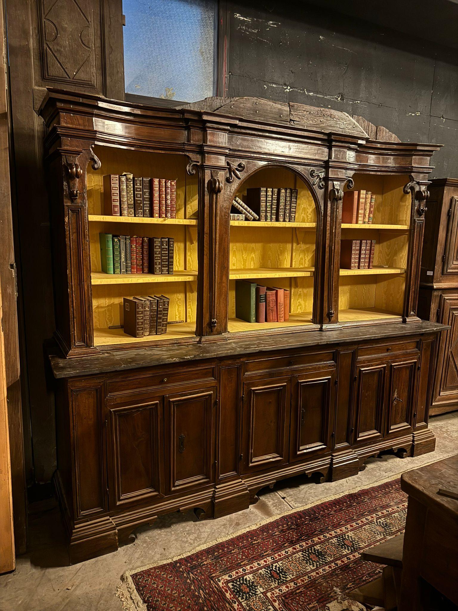 Antikes Bücherregal aus Nussbaumholz mit geschnitzten Säulen und Kapitellen, Sockel mit unteren Türen und offenem Oberteil, daher mit offenen Einlegeböden, original aus Italien, 18. Jahrhundert. Maximale Abmessungen cm B 251 x H 212 x T 63, sehr