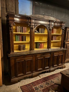 Walnut bookcase with carved columns, doors and open shelves, Italy