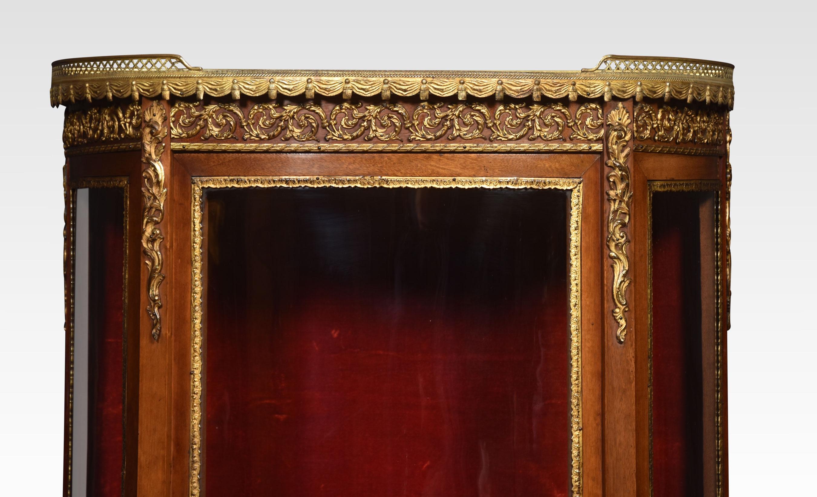 Walnut display cabinet, the shaped marble top with raised three quarter ormolu gallery, above glass sides and bow fronteded door enclosing upholstered interior with two fixed shelves. All raised up on elegantly curved legs with ormolu