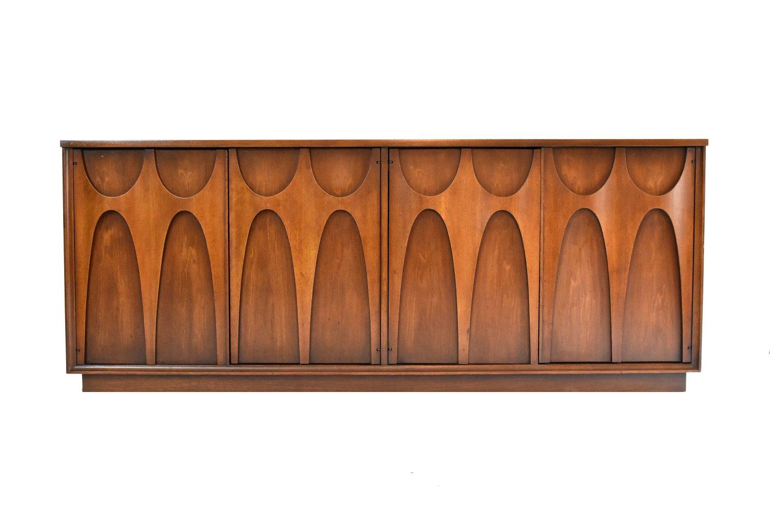The largest and hard to find piece in the Brasilia collection by Broyhill, this stunning midcentury hutch and buffet remains in nearly pristine condition. The hutch is lit, and has two glass shelves for display. The credenza buffet features unique,
