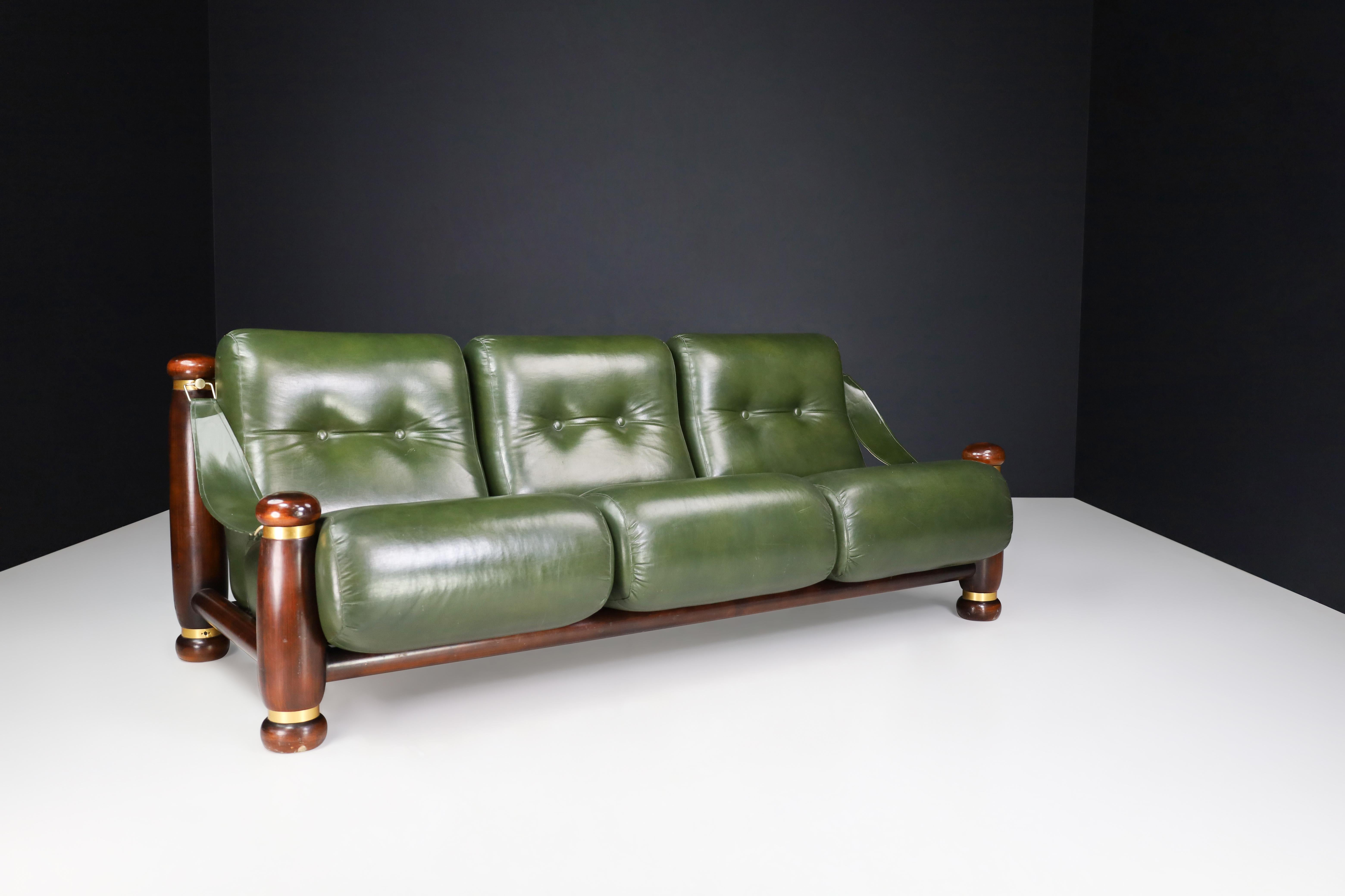 Walnut, Brass, And Green leather Three-seat sofa from Italy 1960s

This bulky lounge three-seat sofa, made in Italy during the 1960s, features a stylish design that combines walnut, brass, and leather elements. This large sofa would make a