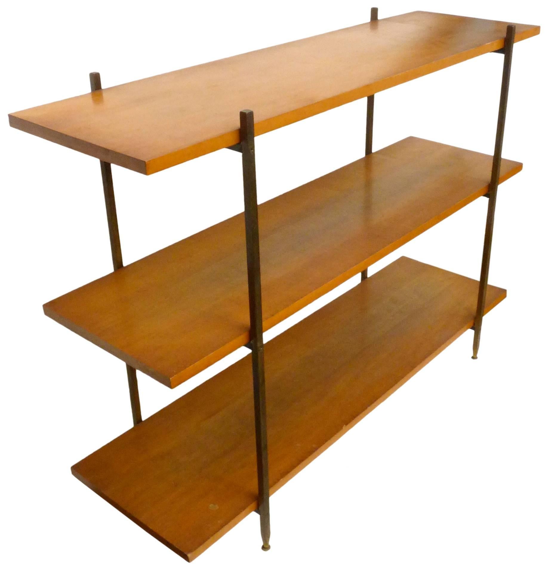 An elegant shelving unit in walnut, brass and iron by Milo Baughman for Murray Furniture Co. Classic, midcentury, stylish simplicity; three evenly-spaced and sized walnut shelves held by a square-stock, machined, brass and iron frame, the legs