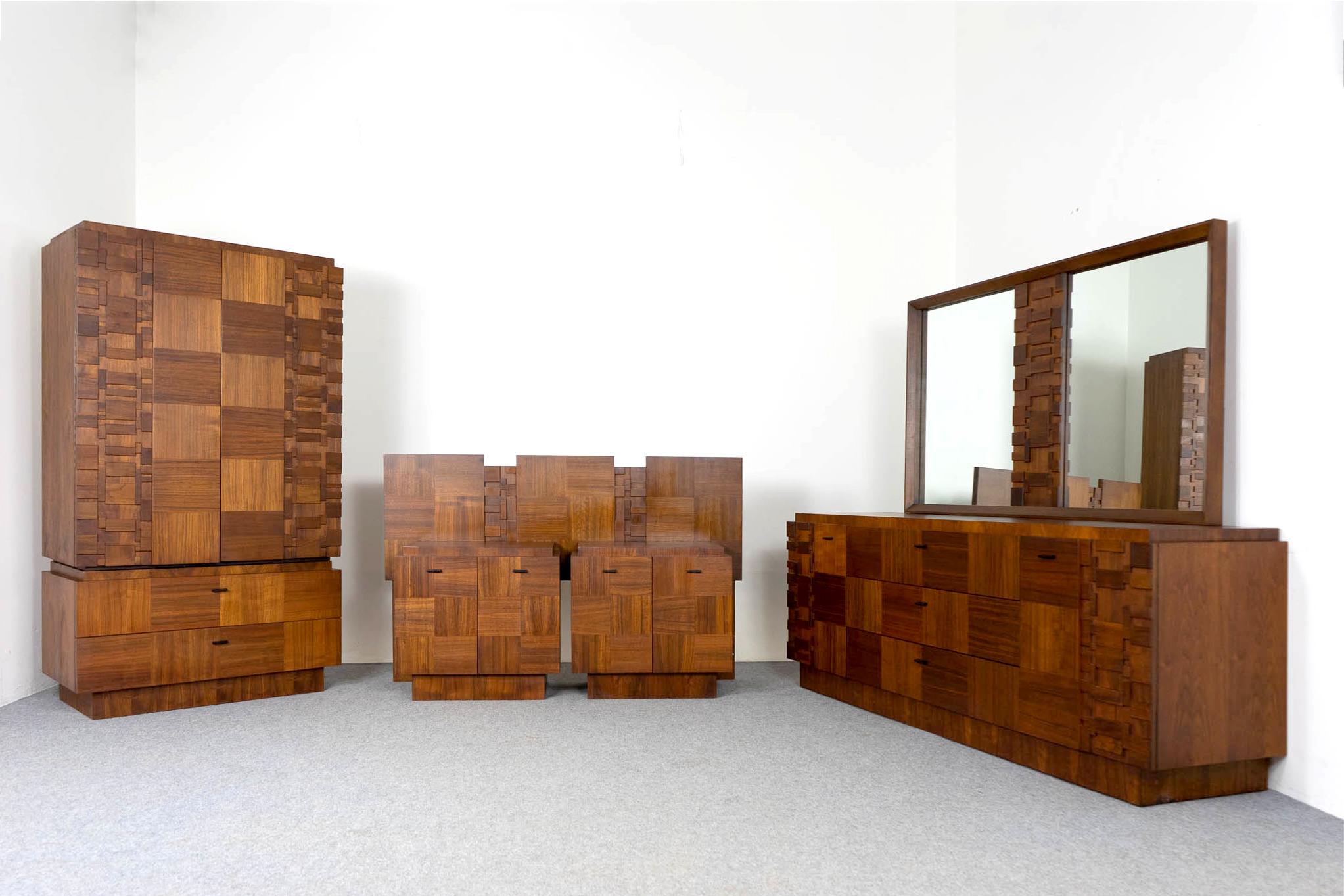 Walnut five piece brutalist bedroom suite, circa 1970's. A sculptural, bold and impressive set with substantial geometric fronts! Low dresser with mirror, gentleman's wardrobe, two bedside tables and a queen sized headboard. Great construction and