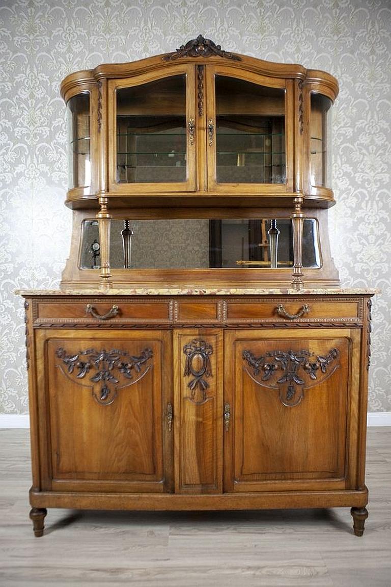 Walnut Buffet from the Interwar Period with Floral Carved Patterns

A grand walnut buffet from the Interwar Period, made in Western Europe.
The two-door piece with drawers at the door axis is topped with marble. The rounded add-on unit with filleted